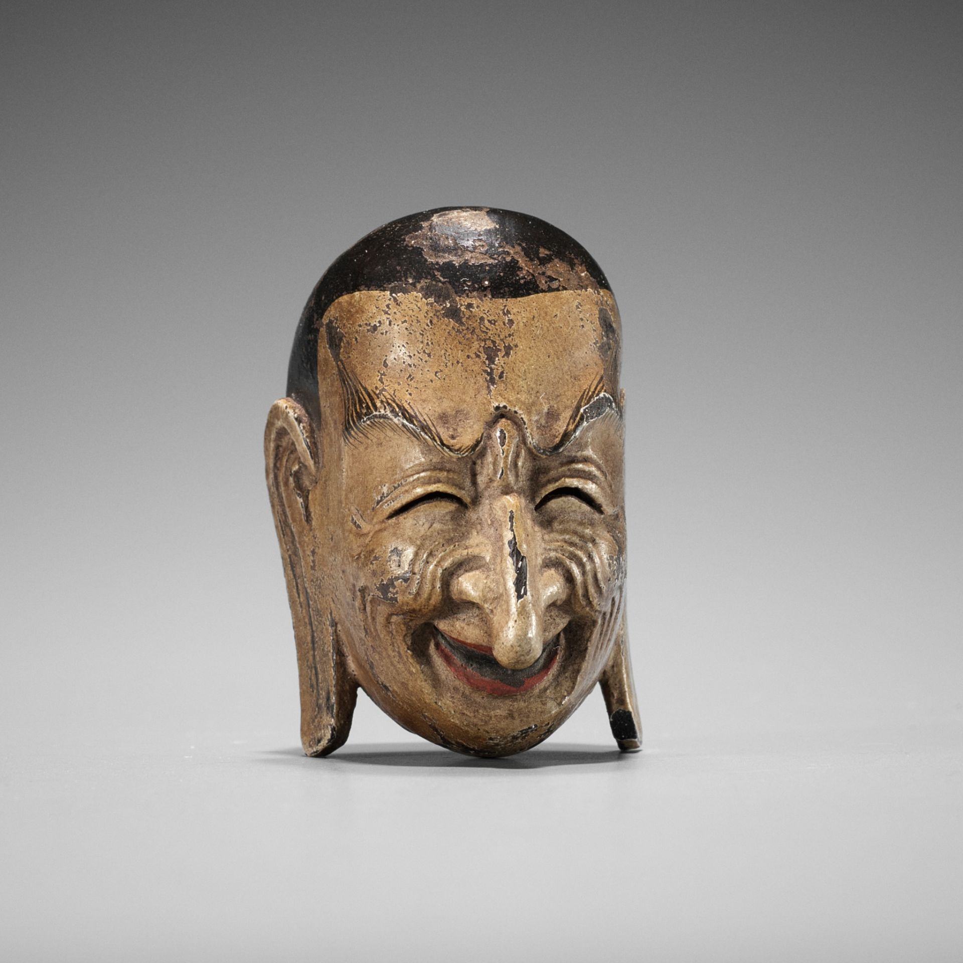 TETSURO: A LACQUERED WOOD GIGAKU MASK NETSUKE OF SUIKO-JU