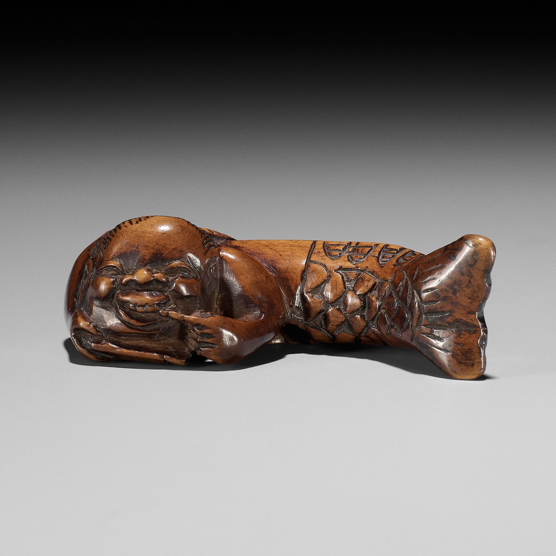 AN EARLY WOOD NETSUKE OF MERMAID (NINGYO) BLACKENING HER TEETH (OHAGURO)