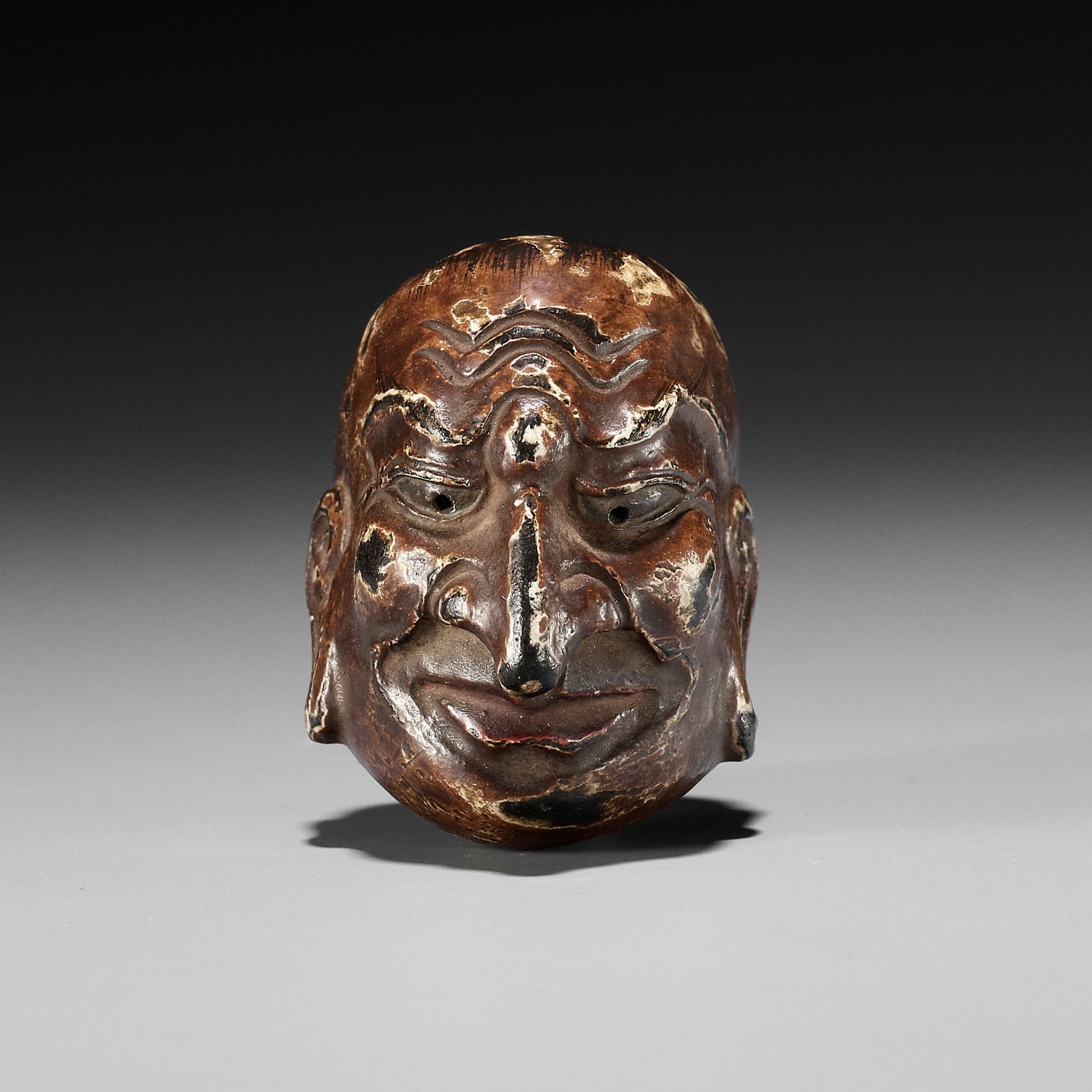 A LACQUERED WOOD GIGAKU MASK NETSUKE OF CHIDO