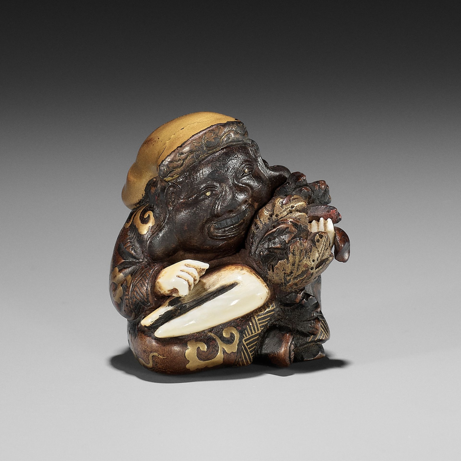 A RARE AND UNUSUAL INLAID AND LACQUERED WOOD NETSUKE OF DAIKOKU