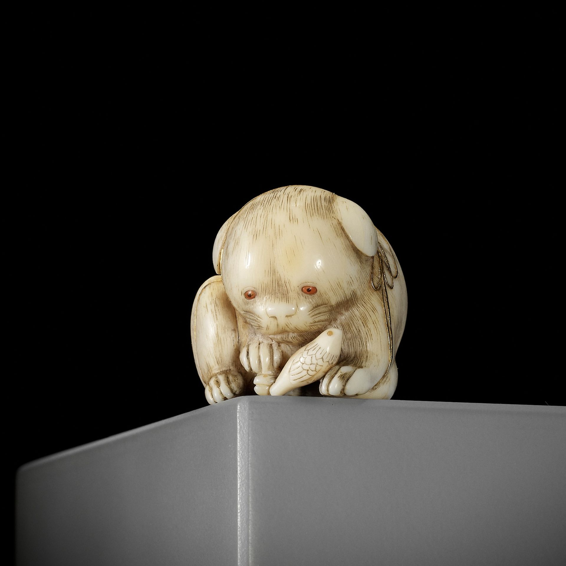 KAIGYOKUSAI MASATSUGU: A SUPERB IVORY NETSUKE OF A PUPPY WITH TOY BIRD