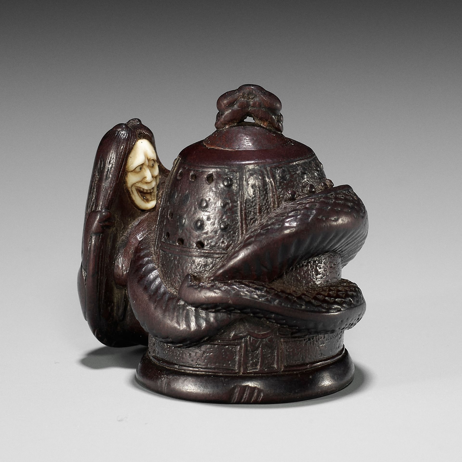 SHIGEYOSHI: AN INLAID DARK WOOD NETSUKE OF KIYOHIME