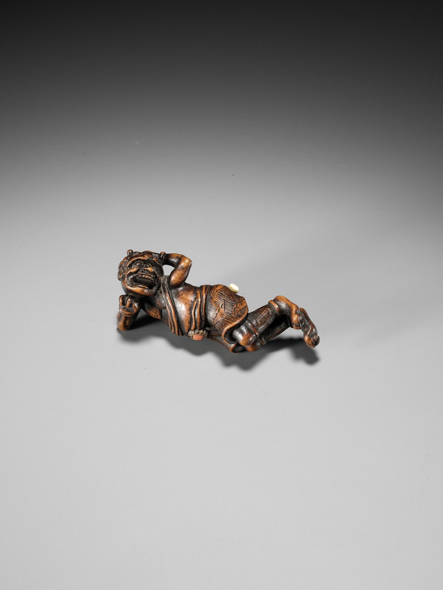 AN INLAID WOOD NETSUKE OF A RECLINING ONI AT SETSUBUN - Image 6 of 10