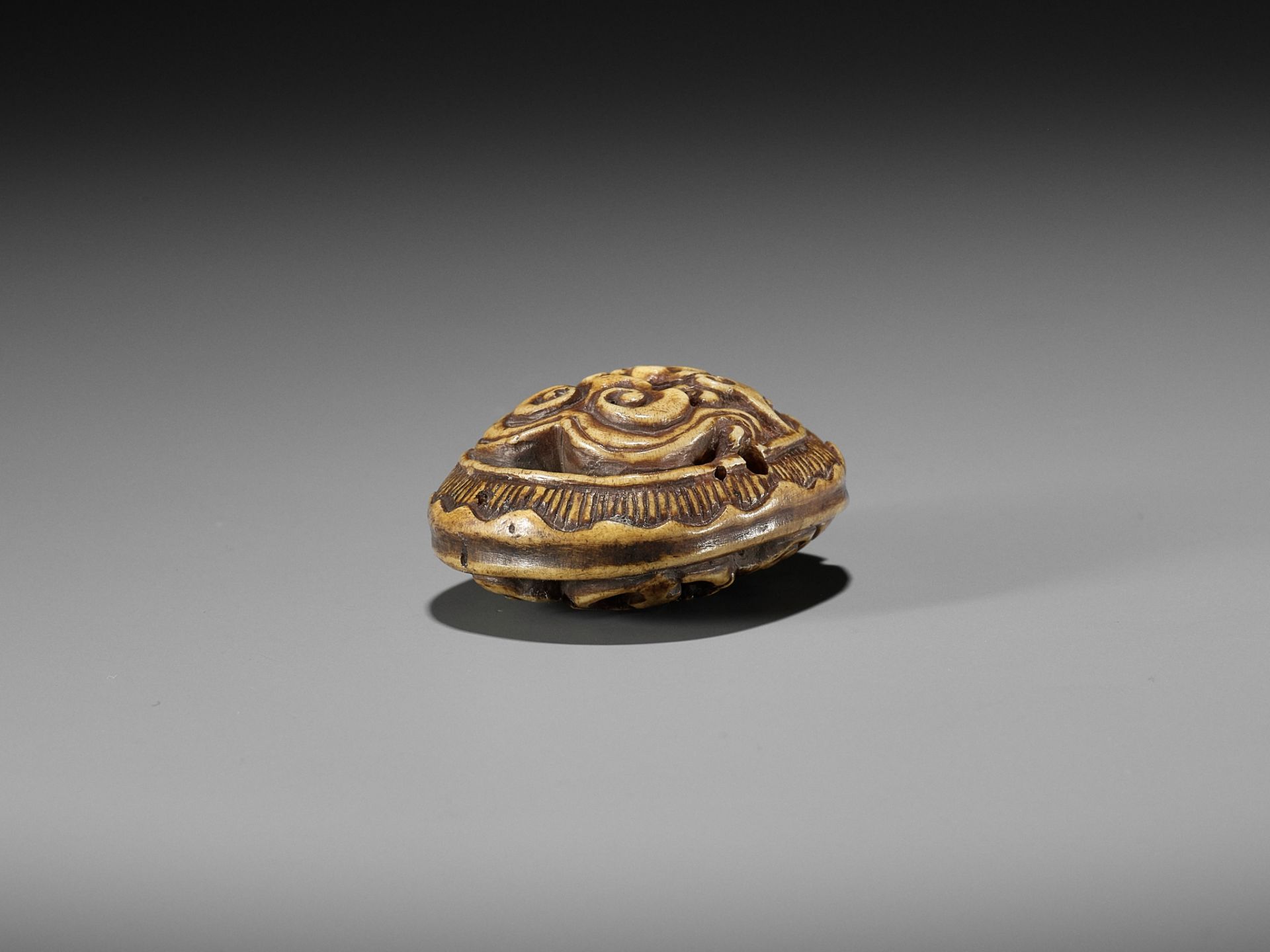 KOKUSAI: A STAG ANTLER RYUSA MANJU NETSUKE DEPICTING A ROOF TILE WITH ONI MASK (ONIGAWARA) - Image 12 of 14