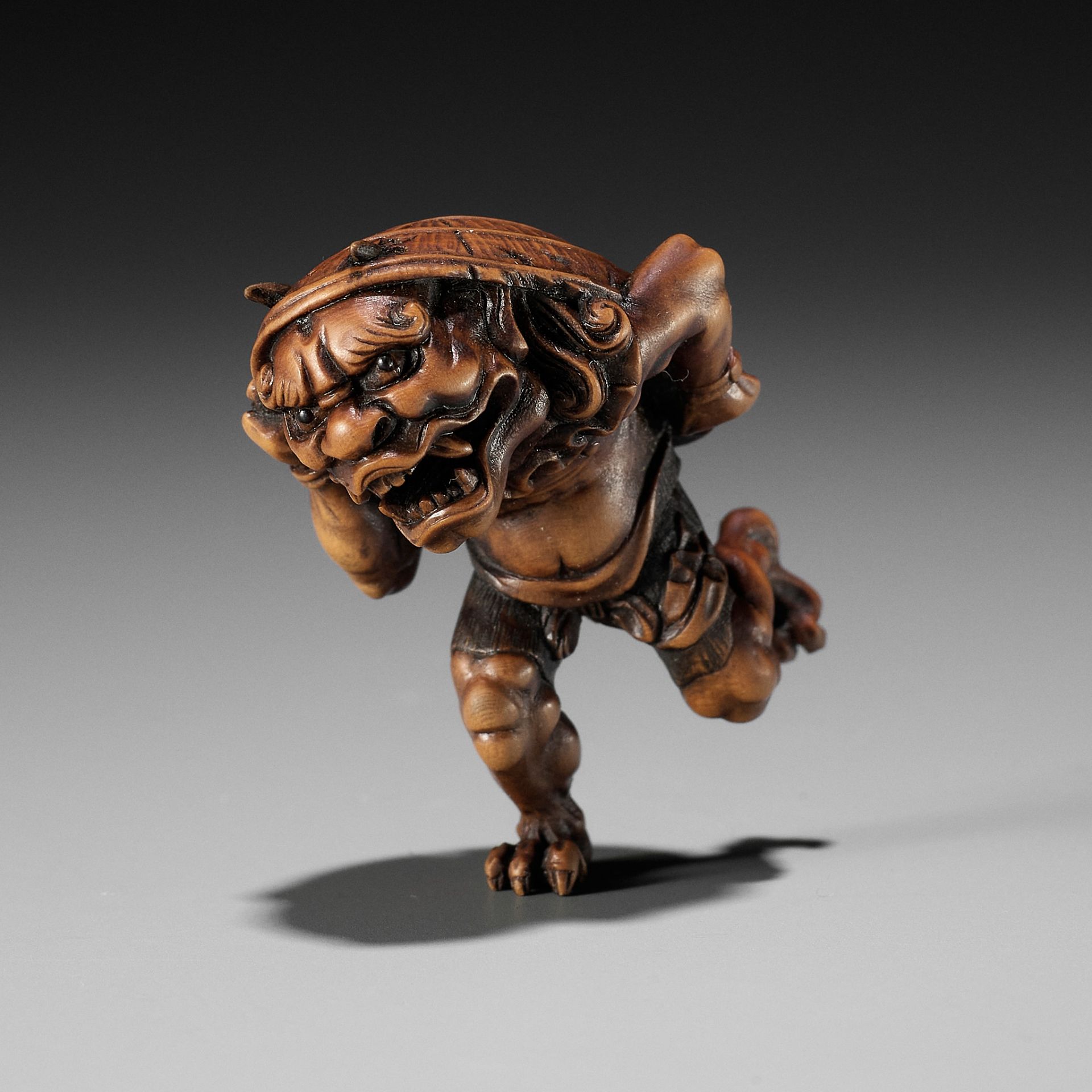 A WOOD NETSUKE OF AN ONI AT SETSUBUN, ATTRIBUTED TO ROKKO