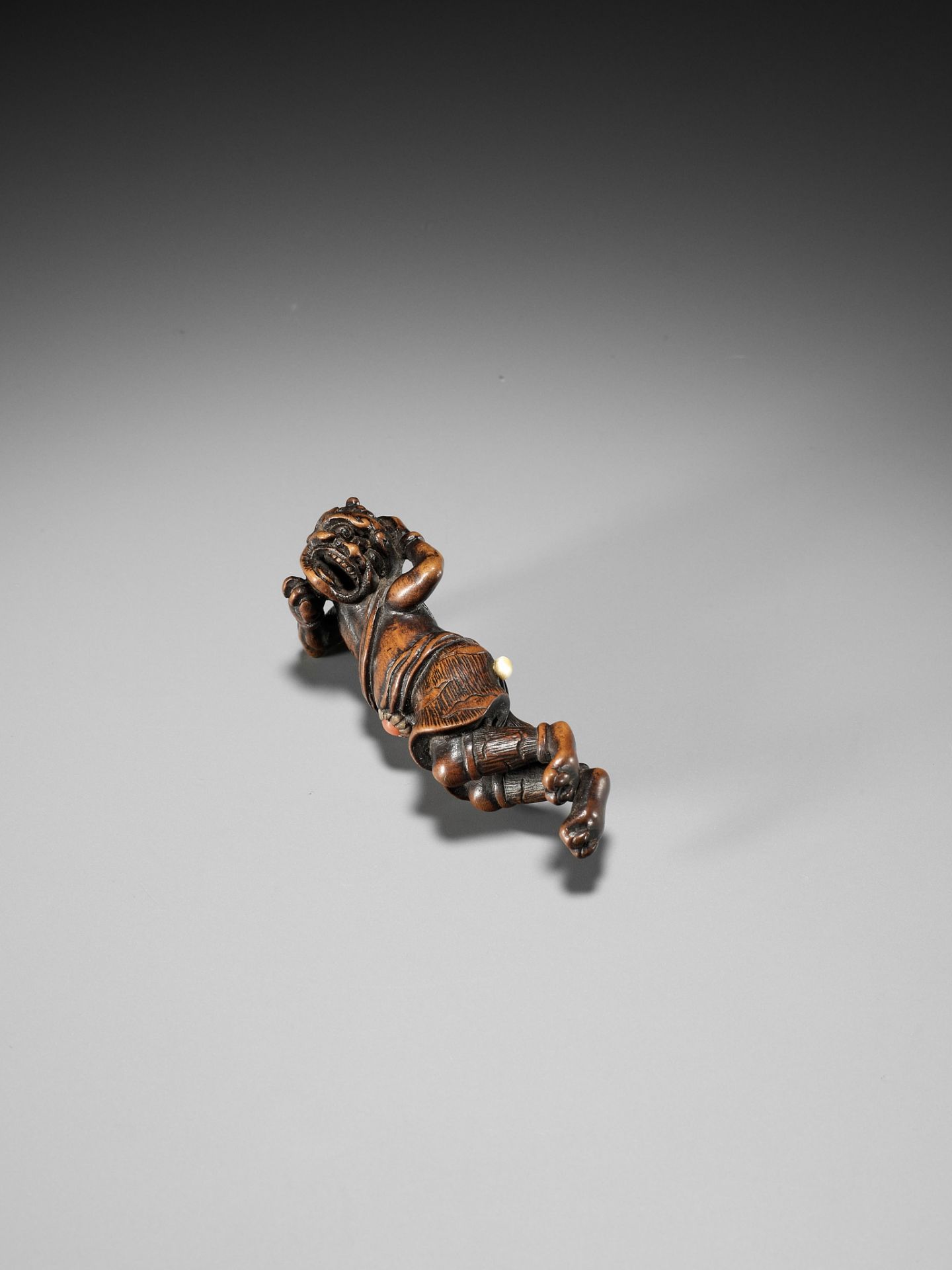 AN INLAID WOOD NETSUKE OF A RECLINING ONI AT SETSUBUN - Image 5 of 10