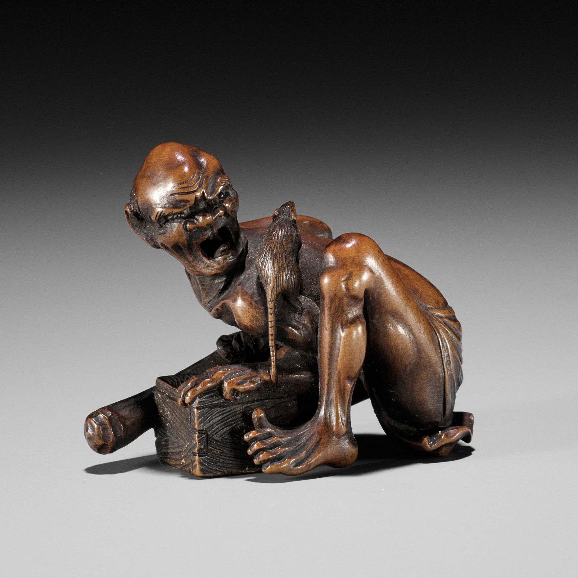 A FINE WOOD OKIMONO NETSUKE OF AN EMACIATED RAT CATCHER