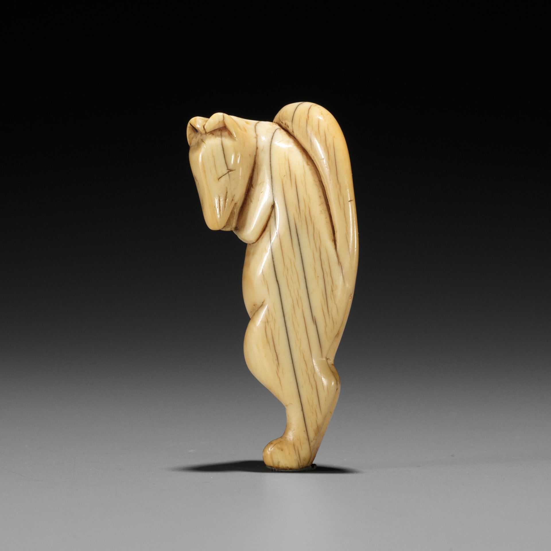 A GOOD IVORY NETSUKE OF A DANCING KITSUNE