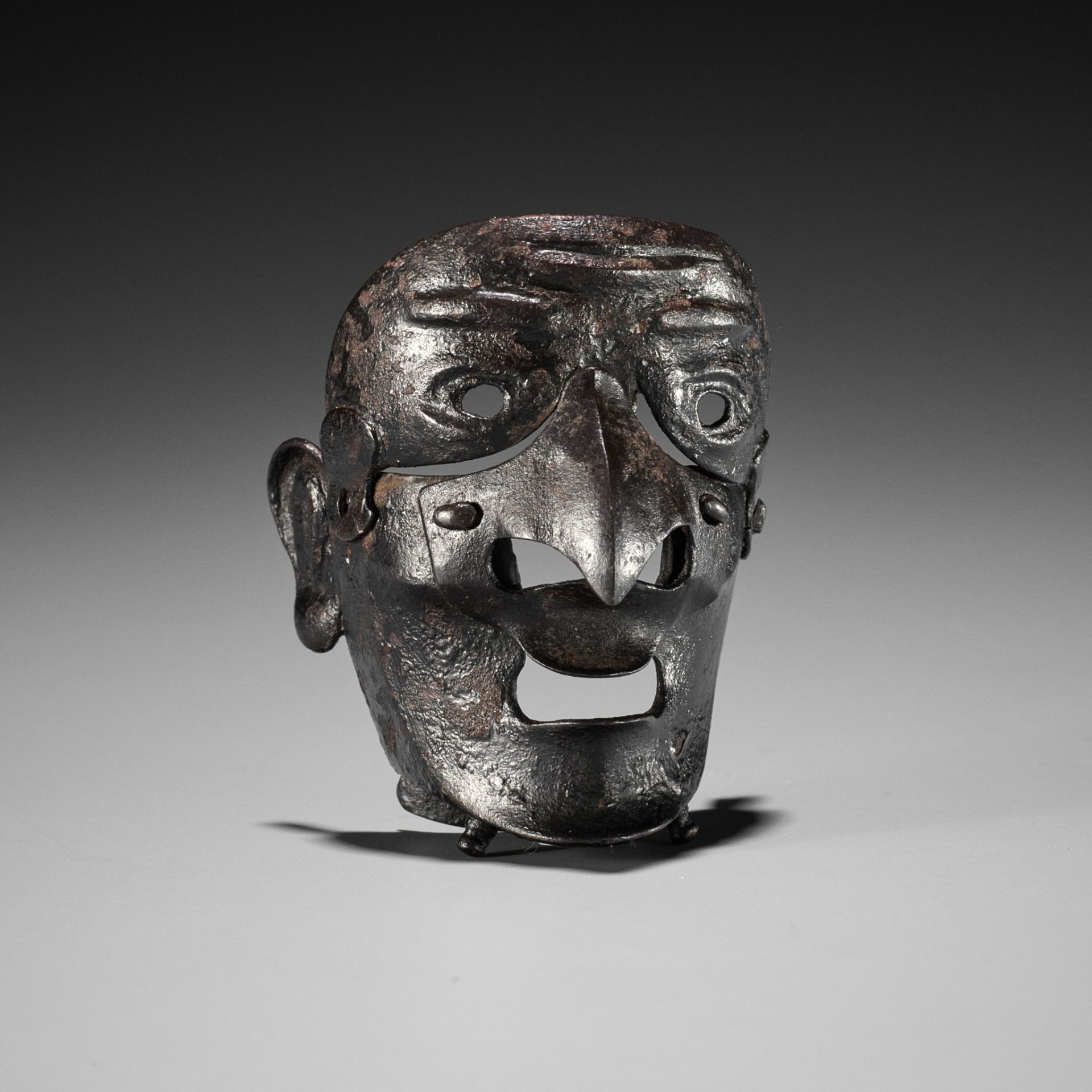 A RARE LACQUERED IRON MASK NETSUKE DEPICTING A TENGU SOMEN