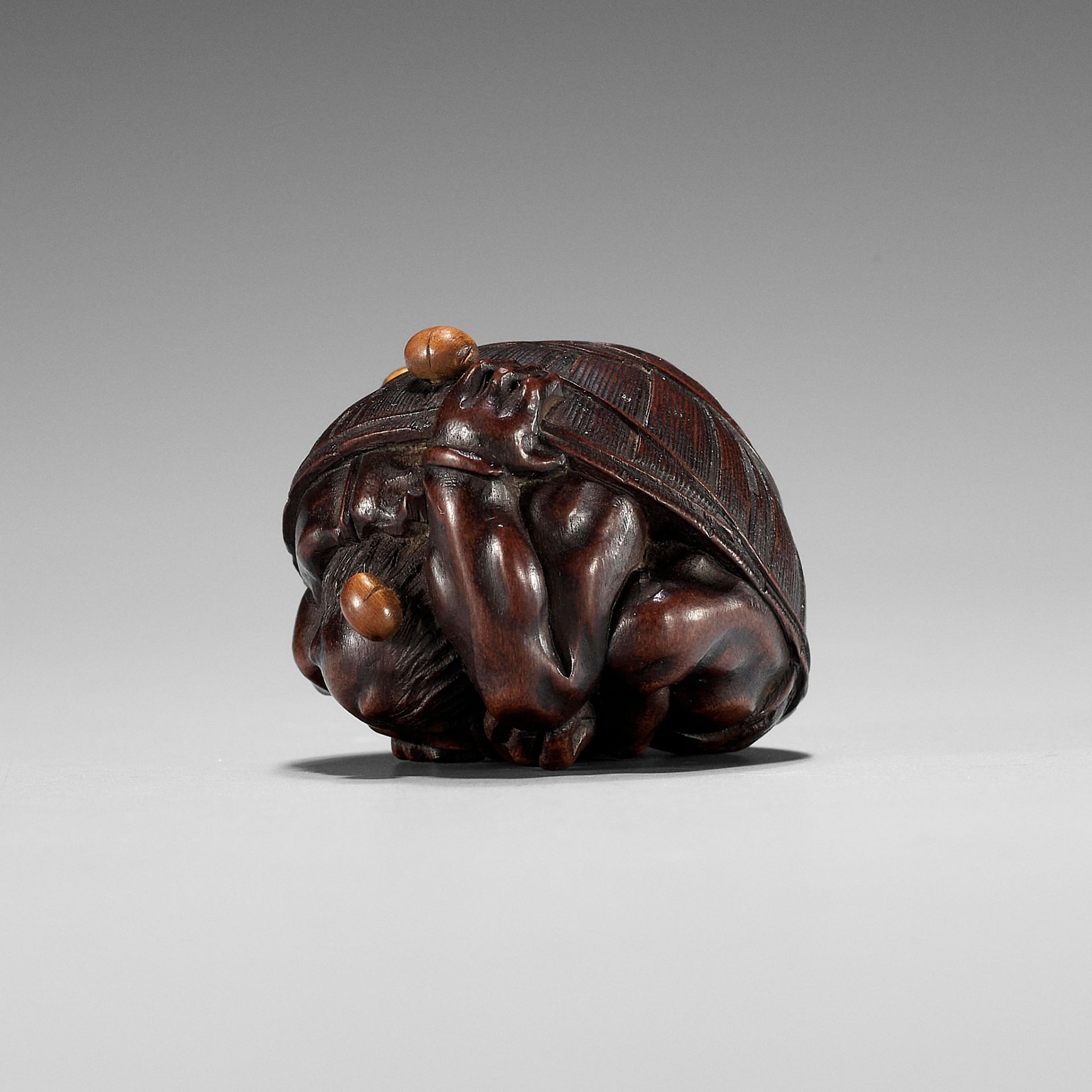 MASAKAZU: A WOOD NETSUKE OF A COWERING ONI DURING SETSUBUN