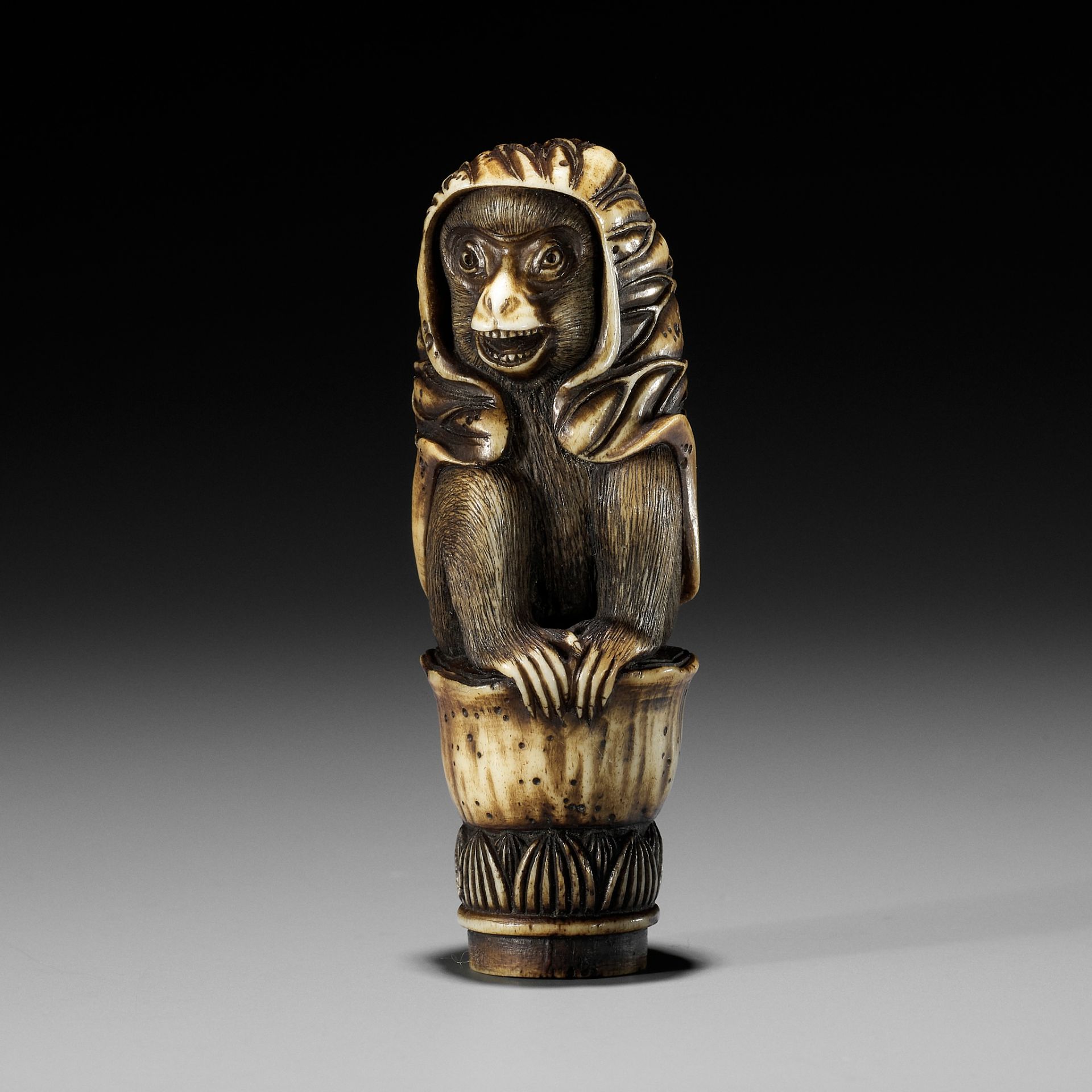 KOKU: A STAG ANTLER KNIFE HANDLE IN THE FORM OF A MONKEY WITH A LOTUS CLOAK