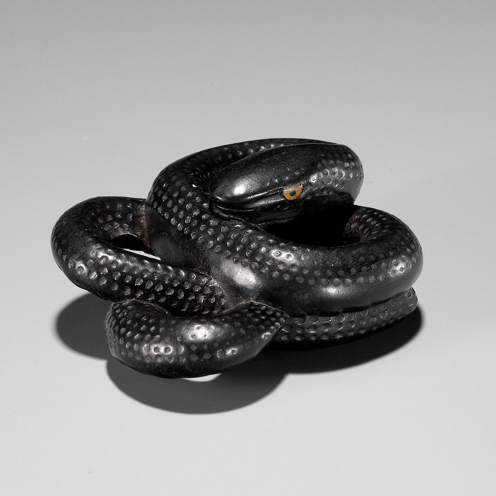 A RARE EBONY WOOD NETSUKE OF COILED SNAKE