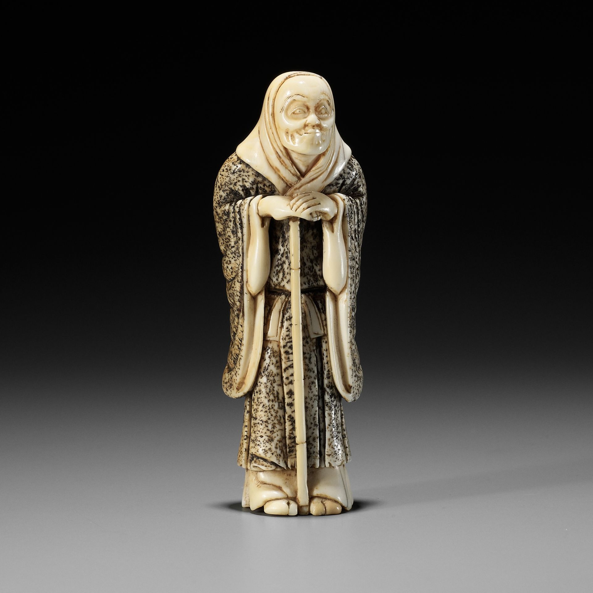 A RARE IVORY NETSUKE OF AN ACTOR IN THE ROLE OF THE FOX PRIEST (HAKUZOSU)