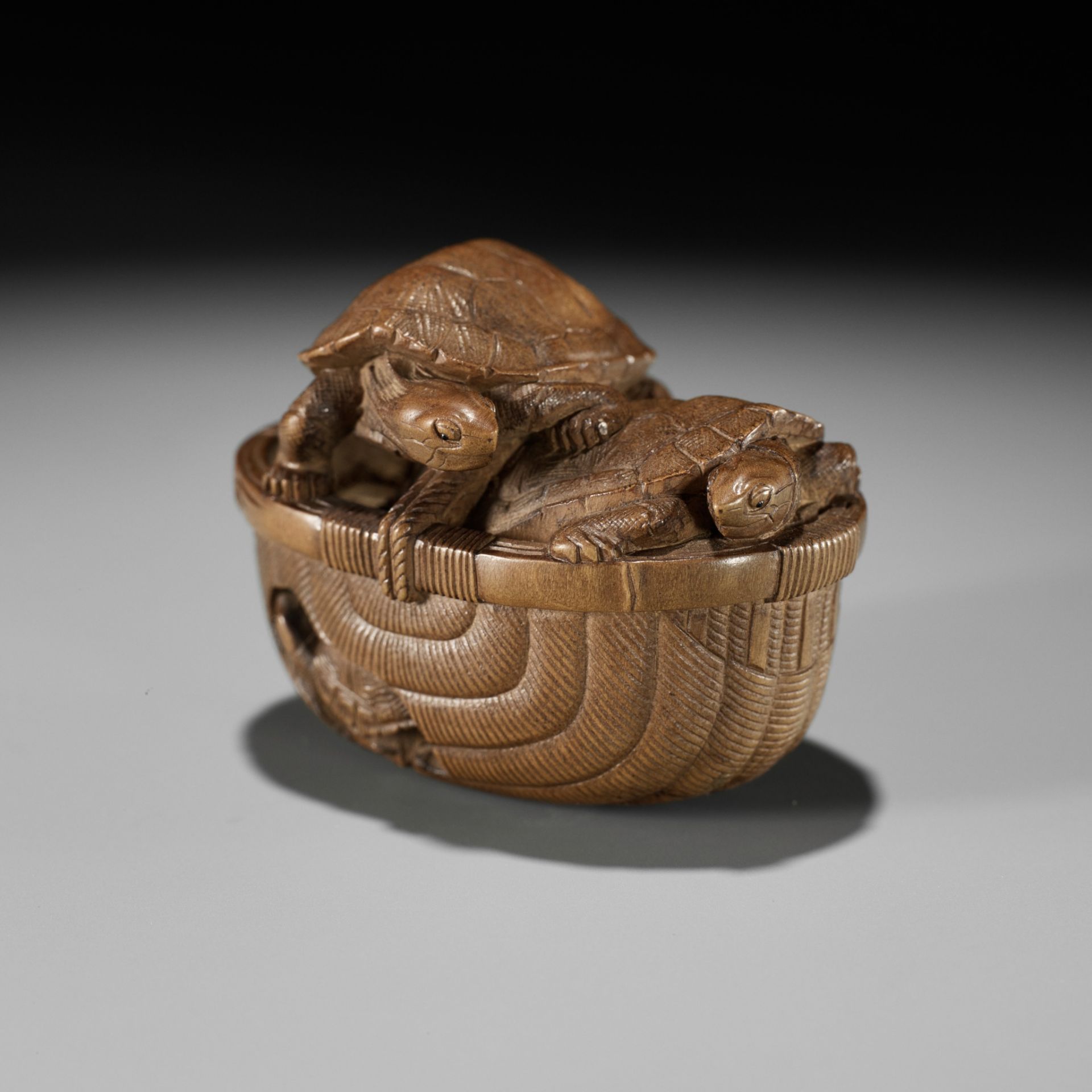 TADAKAZU: A FINE WOOD NETSUKE OF TURTLES IN A BASKET