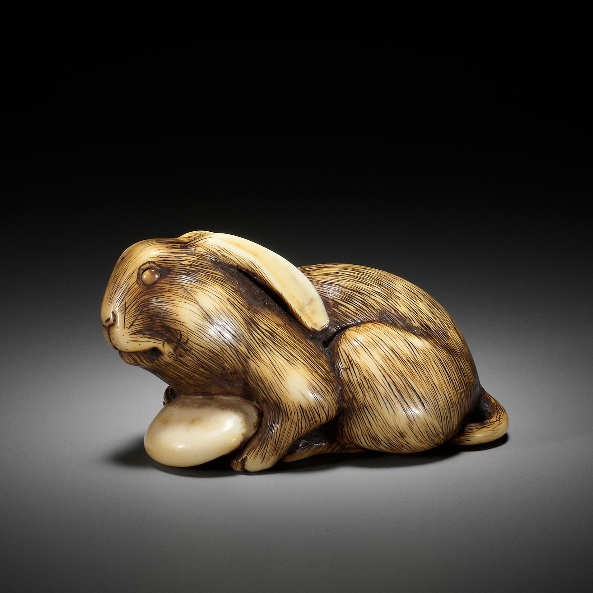 MASATOMO: A RARE IVORY NETSUKE OF A HARE WITH MUSHROOM