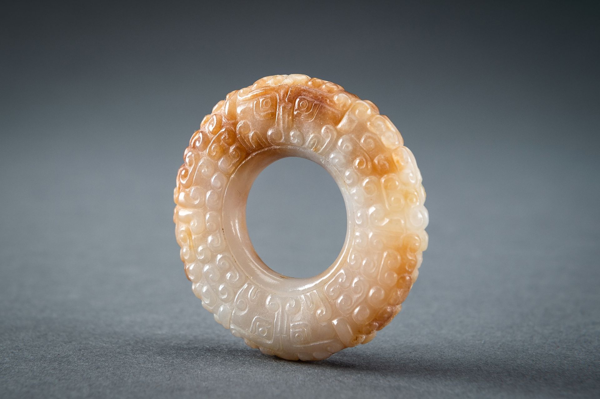 A WHITE AND RUSSET JADE 'CURLS AND TAOTIE MASKS' RING, HUAN, QING - Image 13 of 19