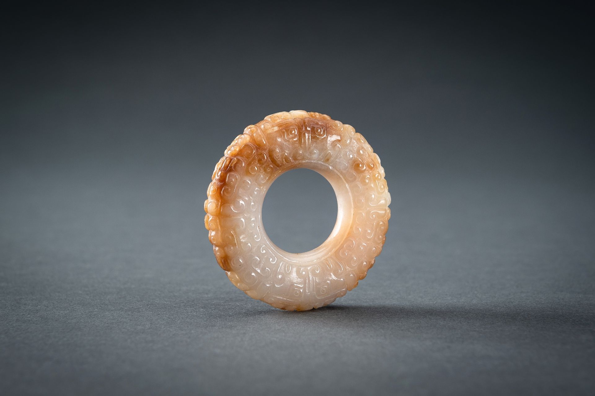 A WHITE AND RUSSET JADE 'CURLS AND TAOTIE MASKS' RING, HUAN, QING - Image 14 of 19