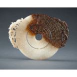 AN ARCHAISTIC WHITE AND BROWN JADE DOUBLE BI DISC, QING