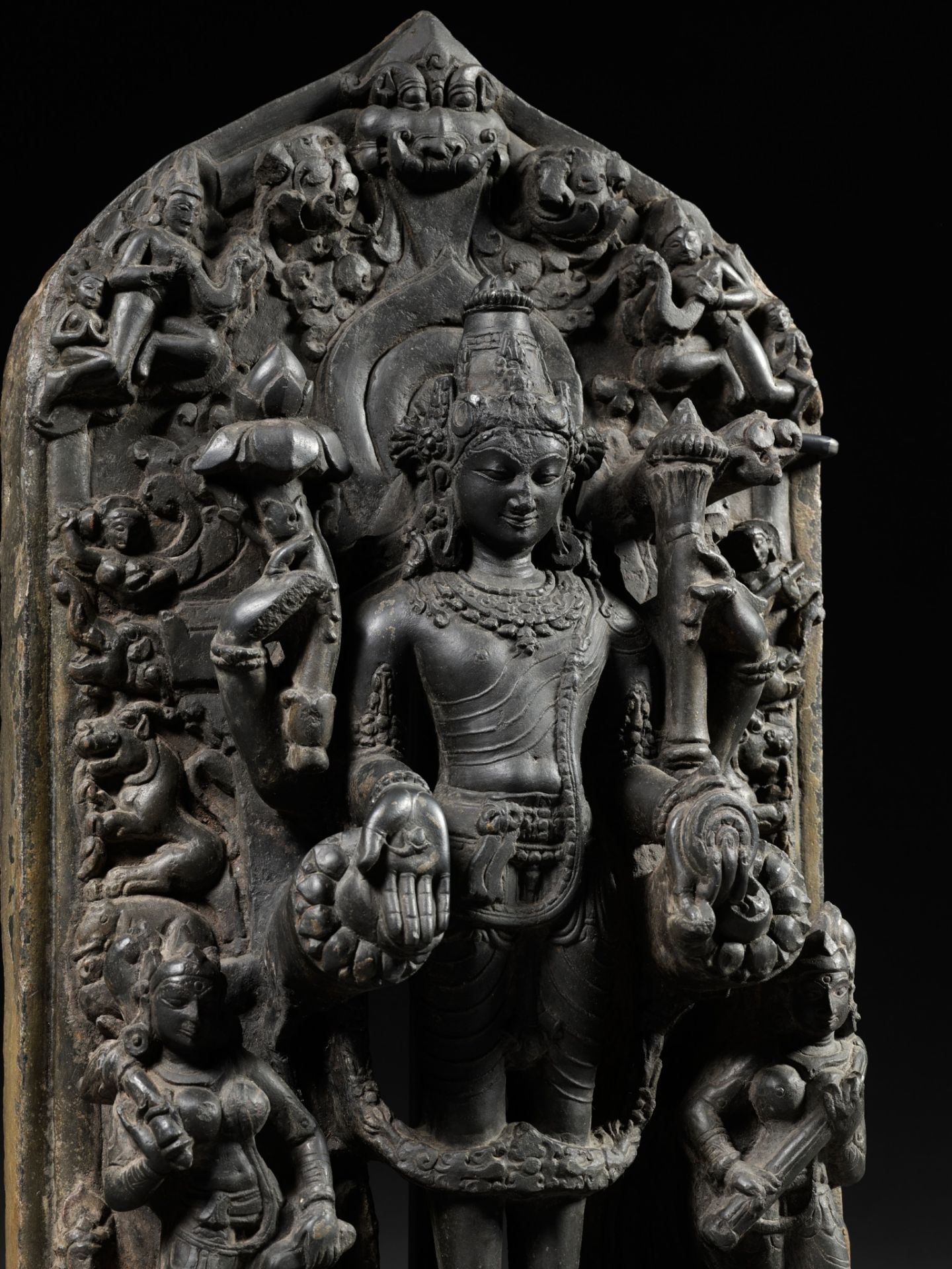 A MASSIVE BLACK STONE TRINITY STELE DEPICTING VISHNU, SARASVATI AND LAKSHMI, PALA PERIOD