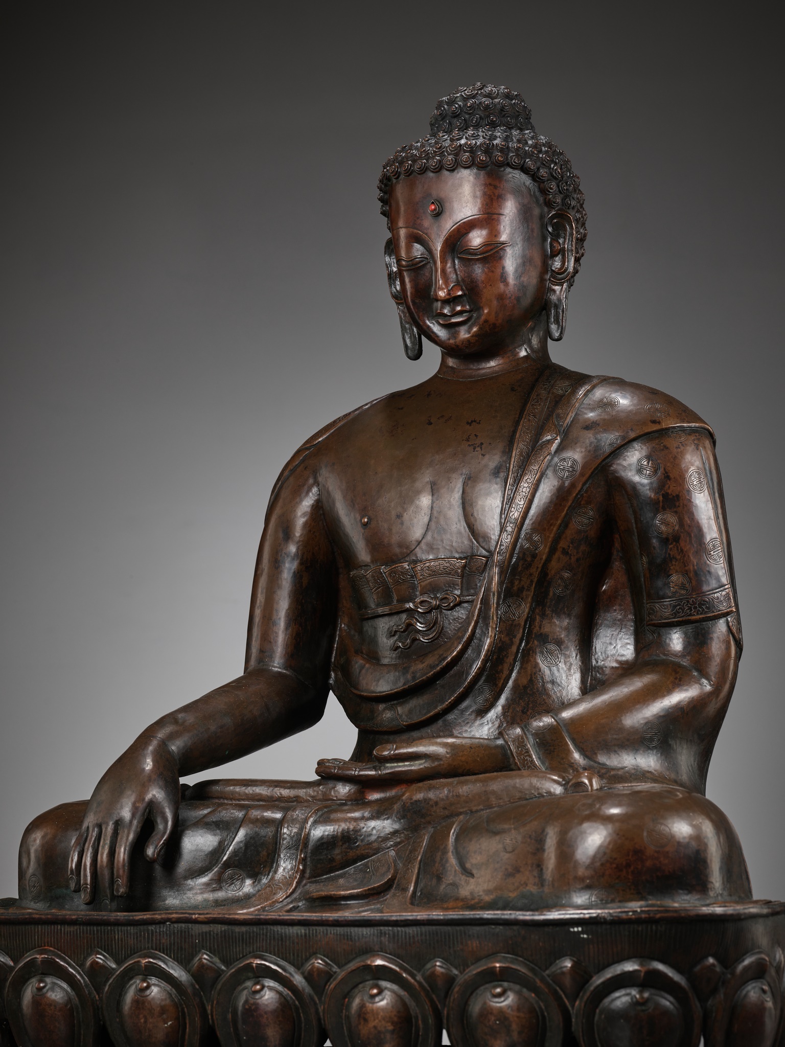 A LARGE CAST AND REPOUSSE COPPER FIGURE OF BUDDHA SHAKYAMUNI, QING DYNASTY