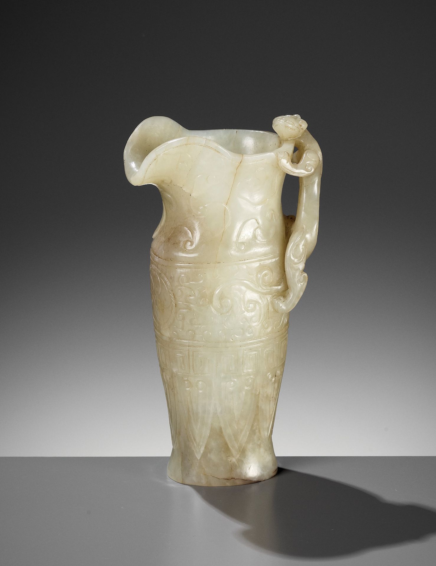 AN IMPERIAL CELADON AND RUSSET JADE 'CHILONG' RHYTON, QIANLONG MARK AND PERIOD