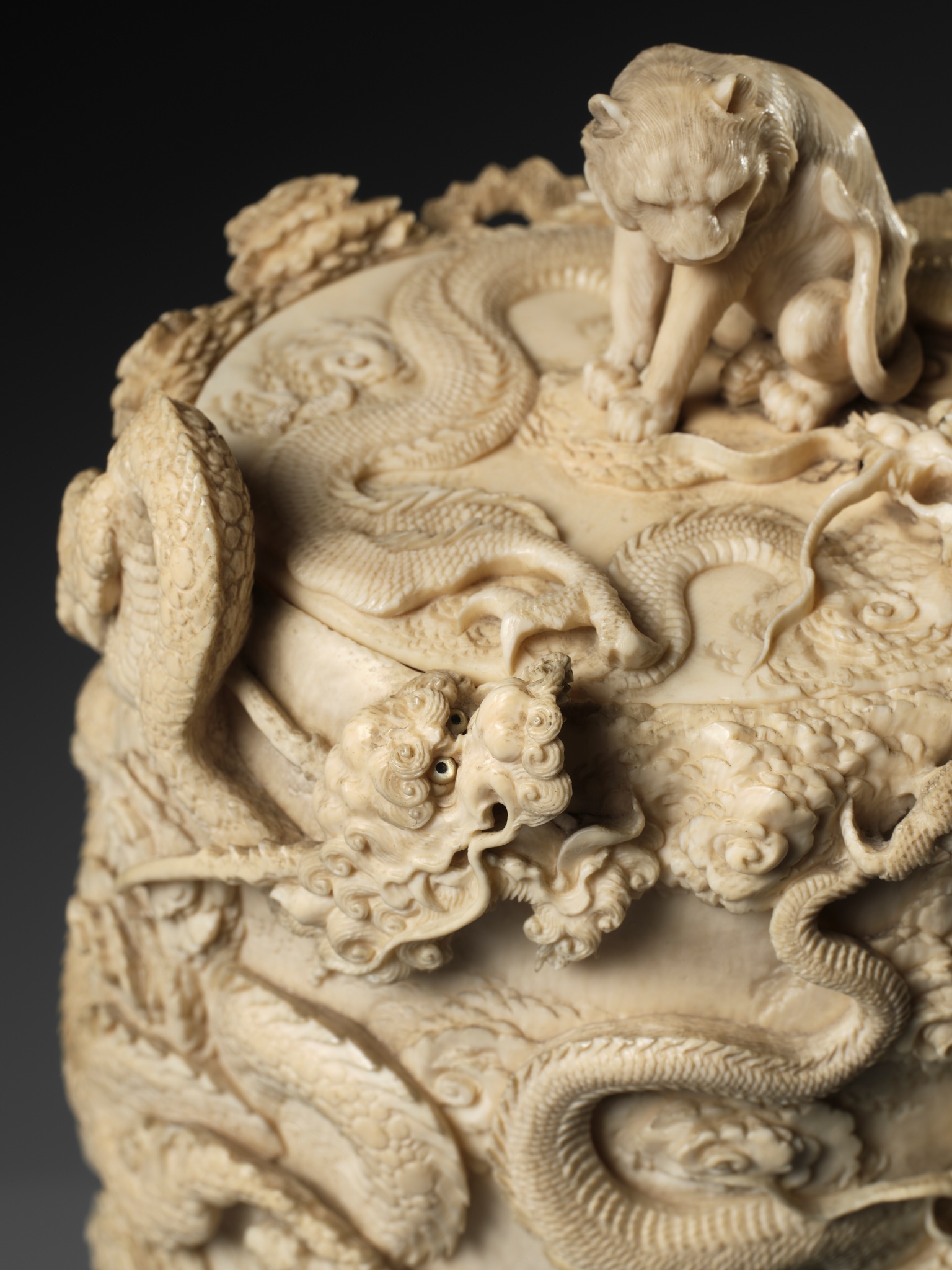 A SUPERB AND LARGE IVORY TUSK BOX AND COVER DEPICTING A TIGER AND DRAGONS