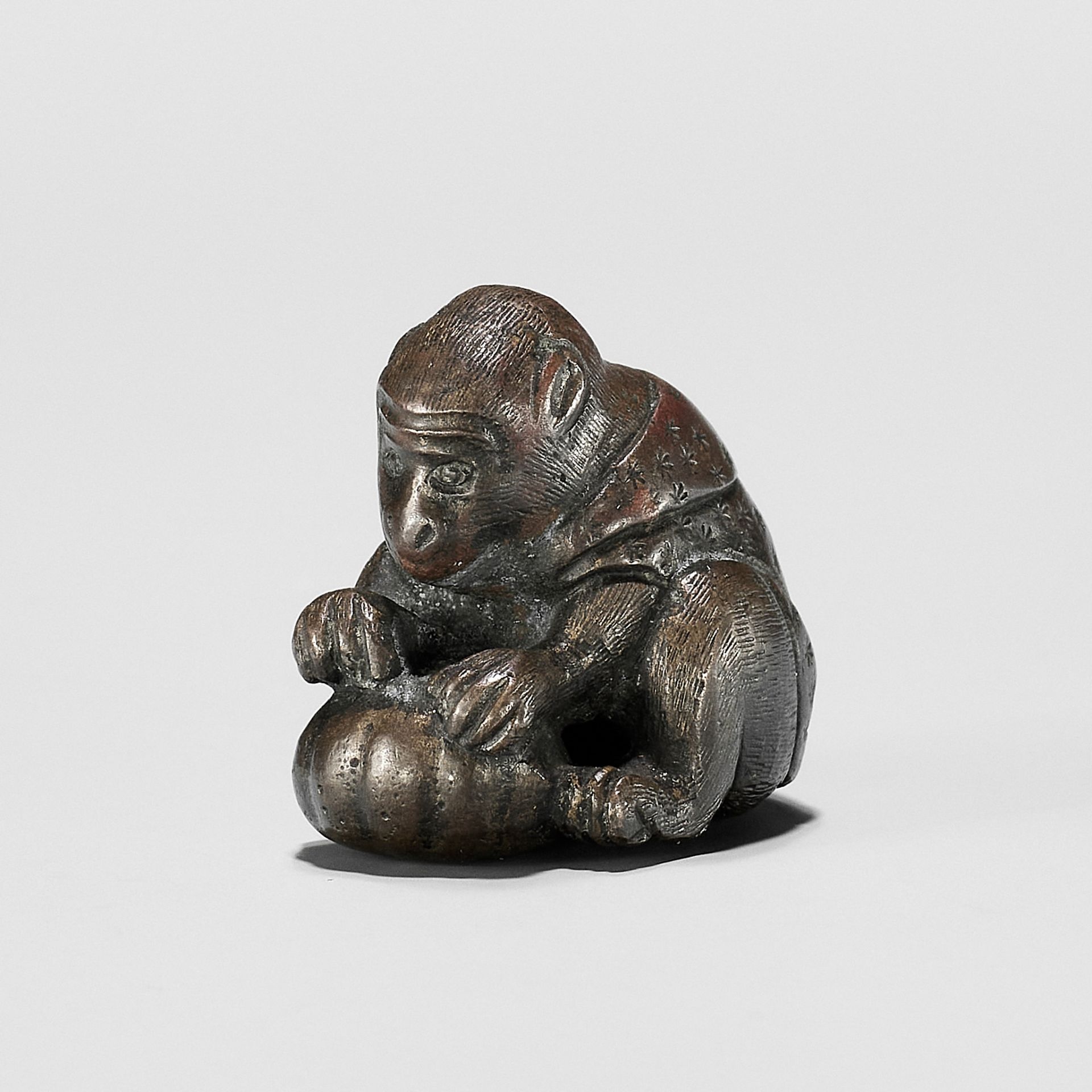 A RARE BRONZE NETSUKE OF A MONKEY WITH GOURD