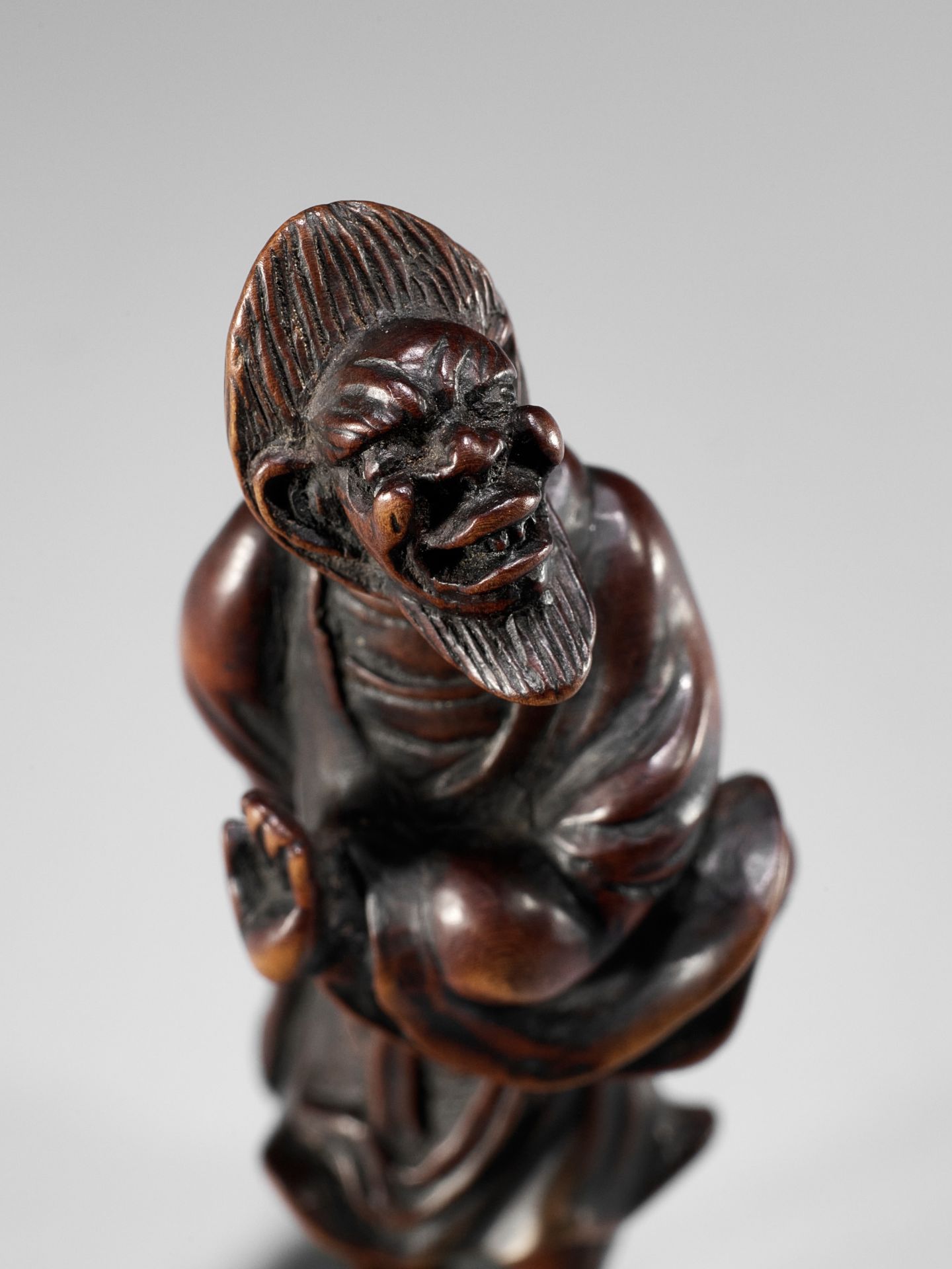 A RARE WOOD NETSUKE OF AN IMMORTAL