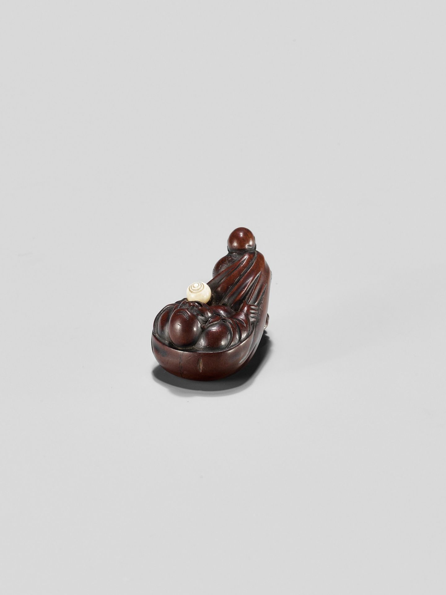 GYOKUMINSAI: A WOOD EDO SCHOOL NETSUKE OF A KARAKO PULLING HOTEI INSIDE HIS TREASURE BAG - Image 6 of 10