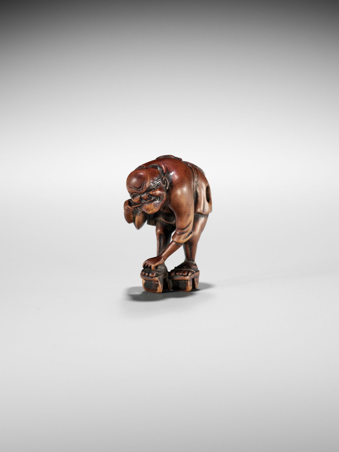 AN EDO SCHOOL WOOD NETSUKE OF A FARMER TYING HIS GETA AND CLEANING HIS TEETH - Image 10 of 11