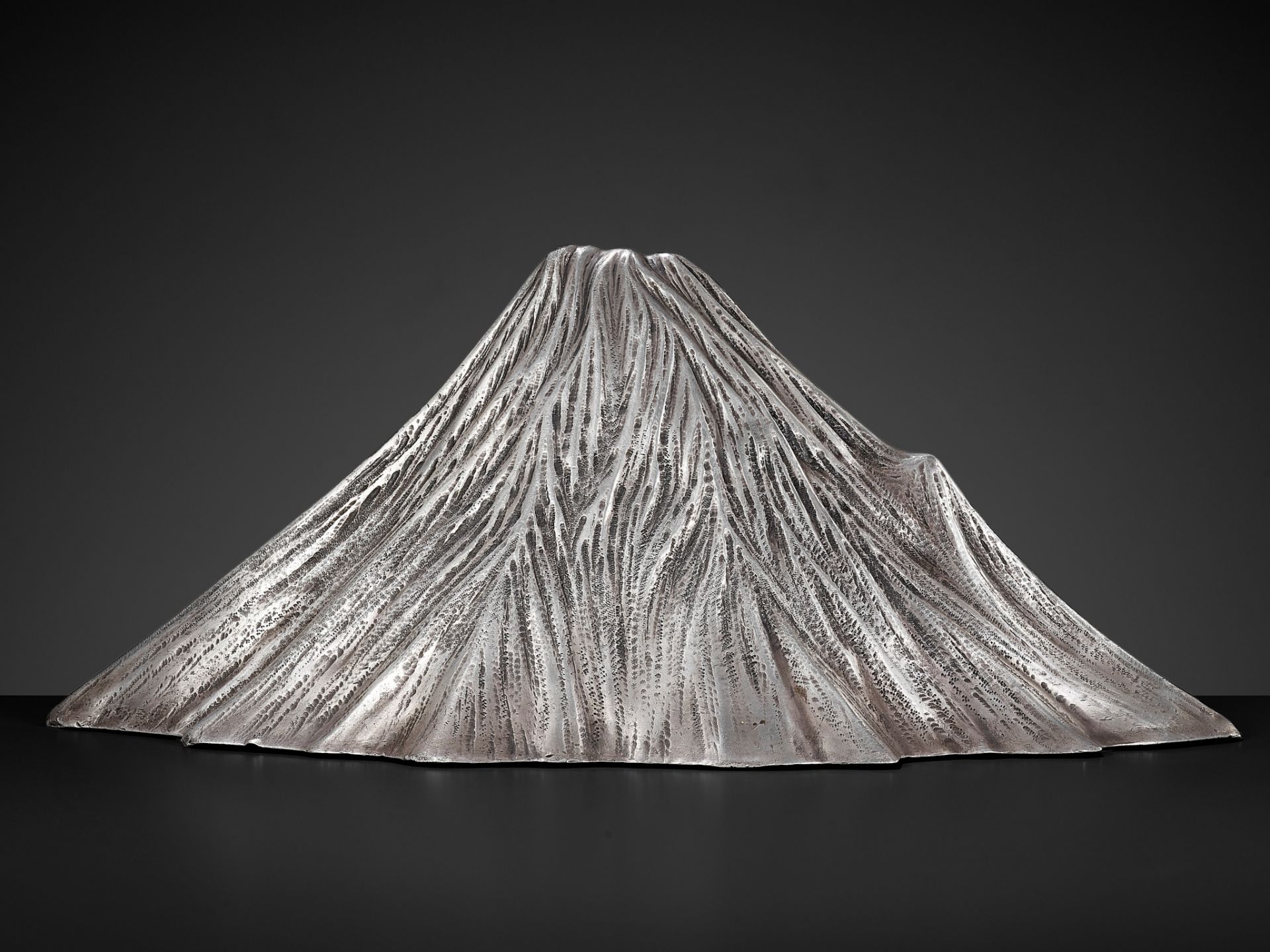 JUKOSHI MITSUTSUGU: AN ICONIC AND LARGE SILVER OKIMONO OF MOUNT FUJI