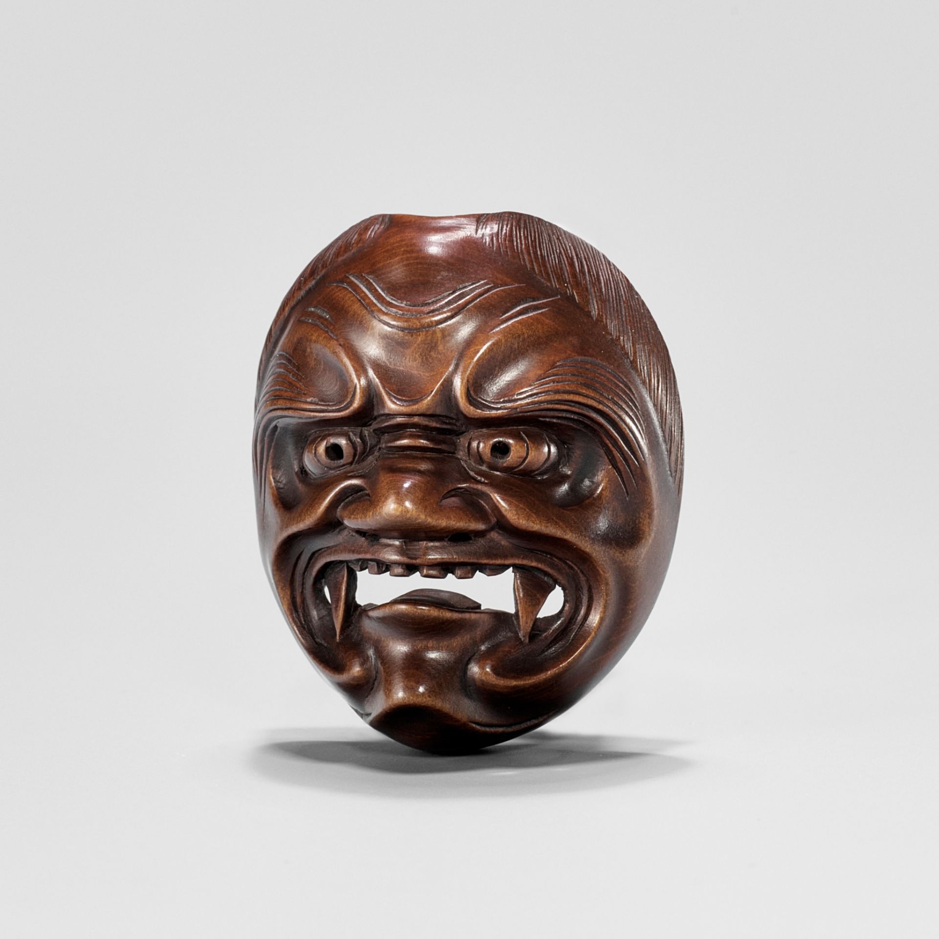 RYUZAN: A WOOD MASK NETSUKE OF SHIKAMI