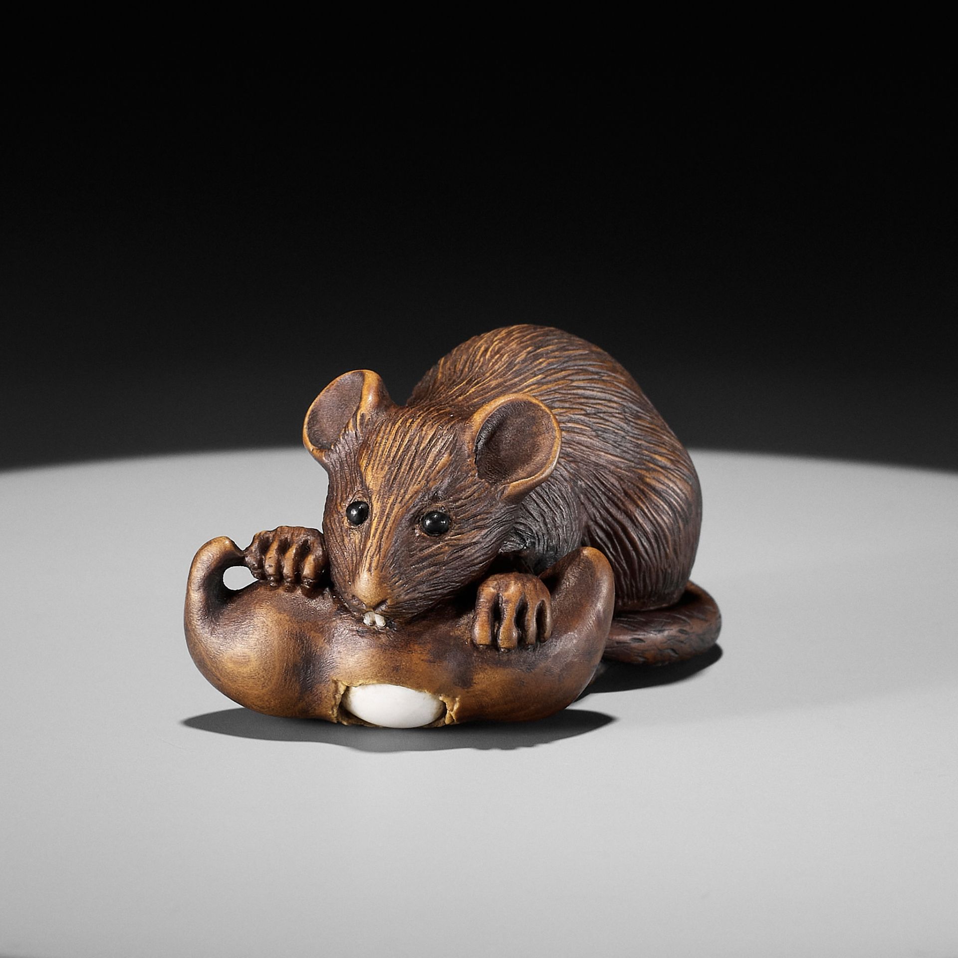 ALEXANDER DERKACHENKO: A WOOD NETSUKE OF A RAT WITH A BEAN-POD