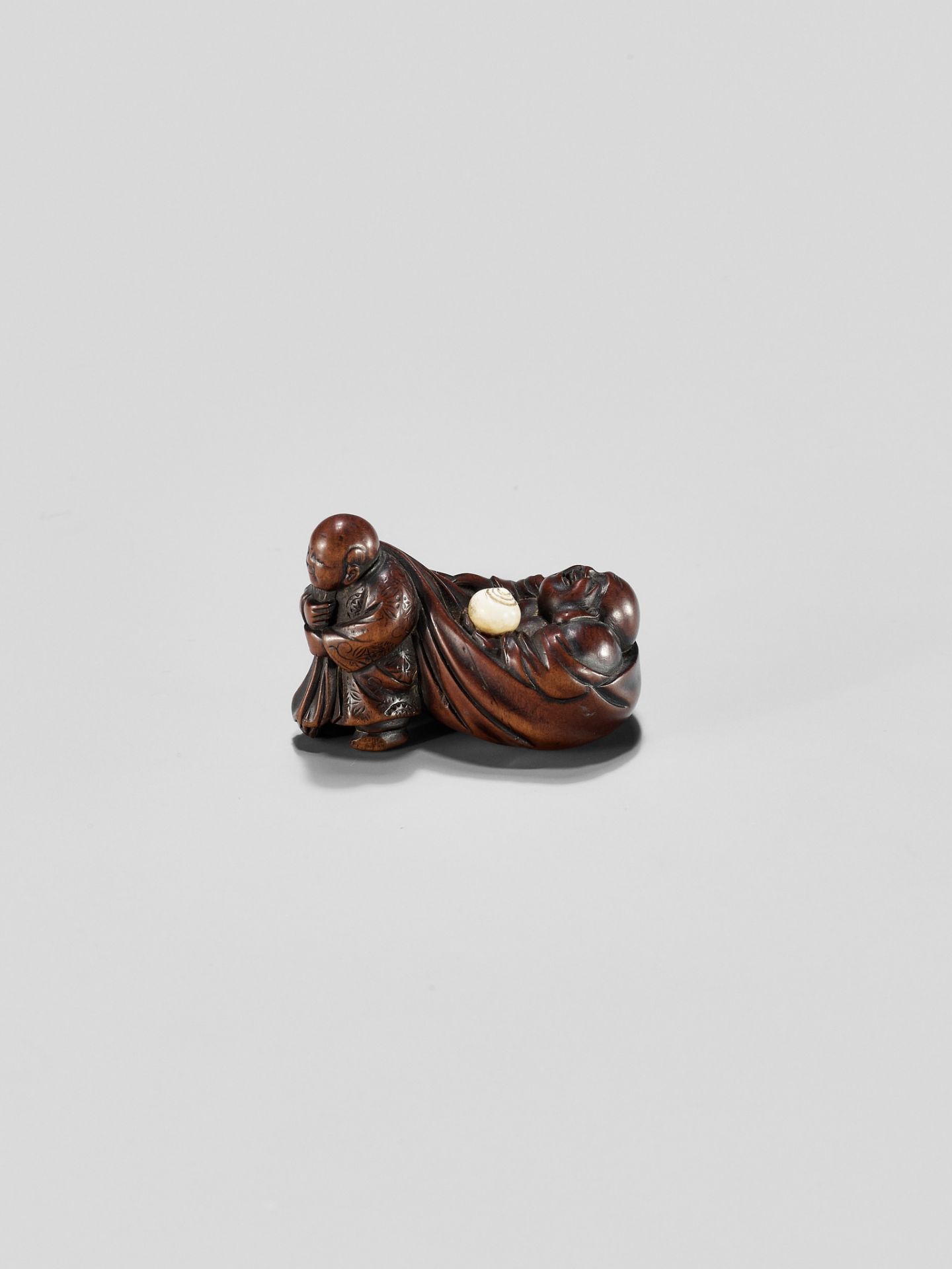 GYOKUMINSAI: A WOOD EDO SCHOOL NETSUKE OF A KARAKO PULLING HOTEI INSIDE HIS TREASURE BAG - Image 4 of 10