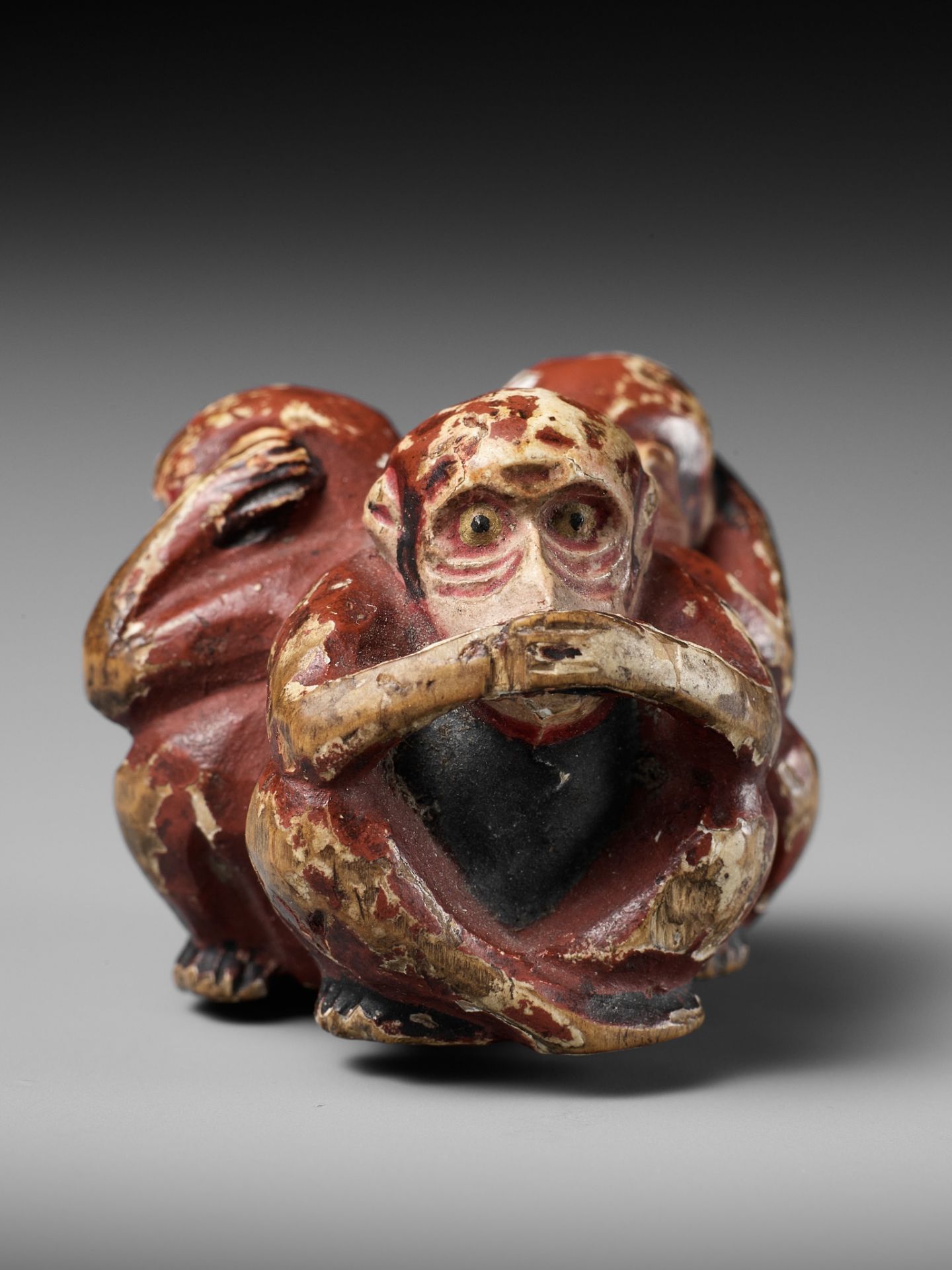 A SAISHIKI (PAINTED WOOD) NETSUKE OF THE SAMBIKI SARU (THREE WISE MONKEYS)