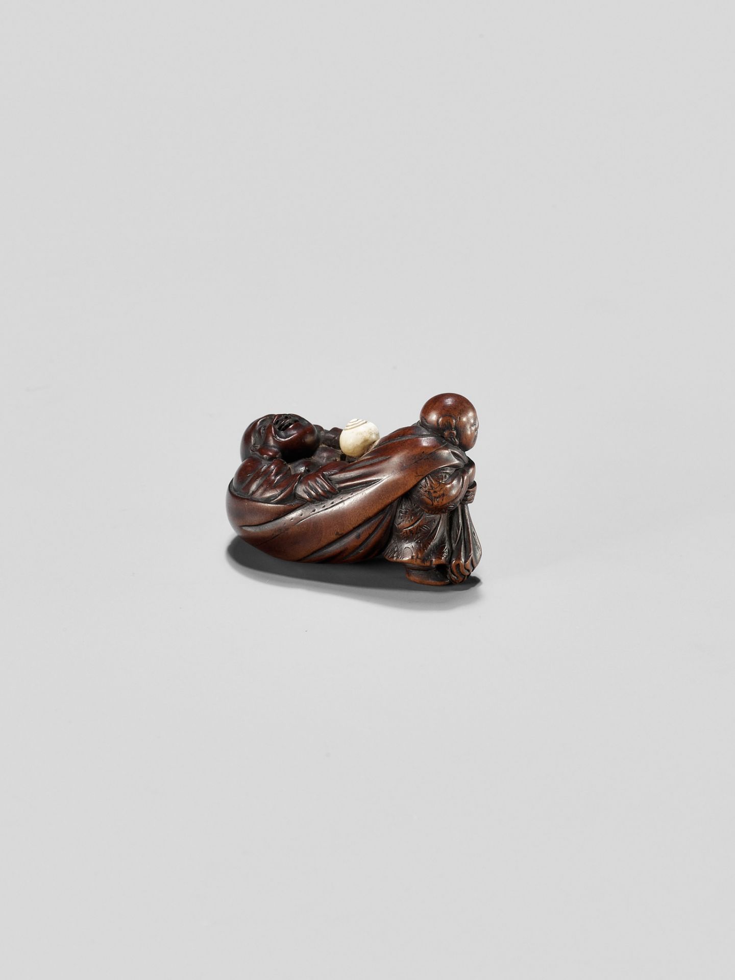 GYOKUMINSAI: A WOOD EDO SCHOOL NETSUKE OF A KARAKO PULLING HOTEI INSIDE HIS TREASURE BAG - Image 7 of 10