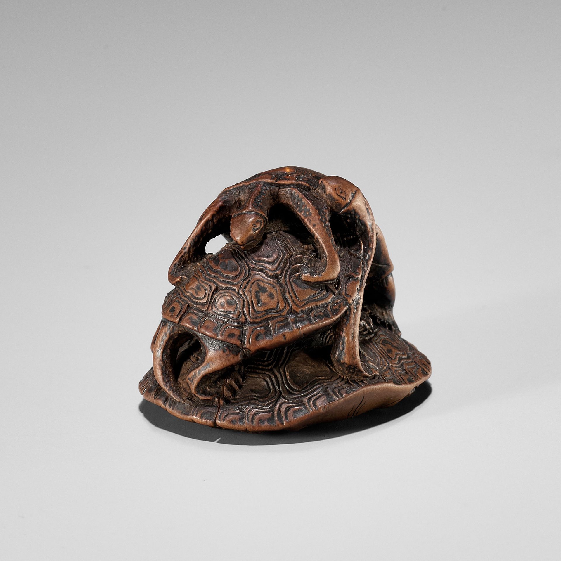 SEIGYOKU: A WOOD NETSUKE OF THREE TURTLES IN A PYRAMID