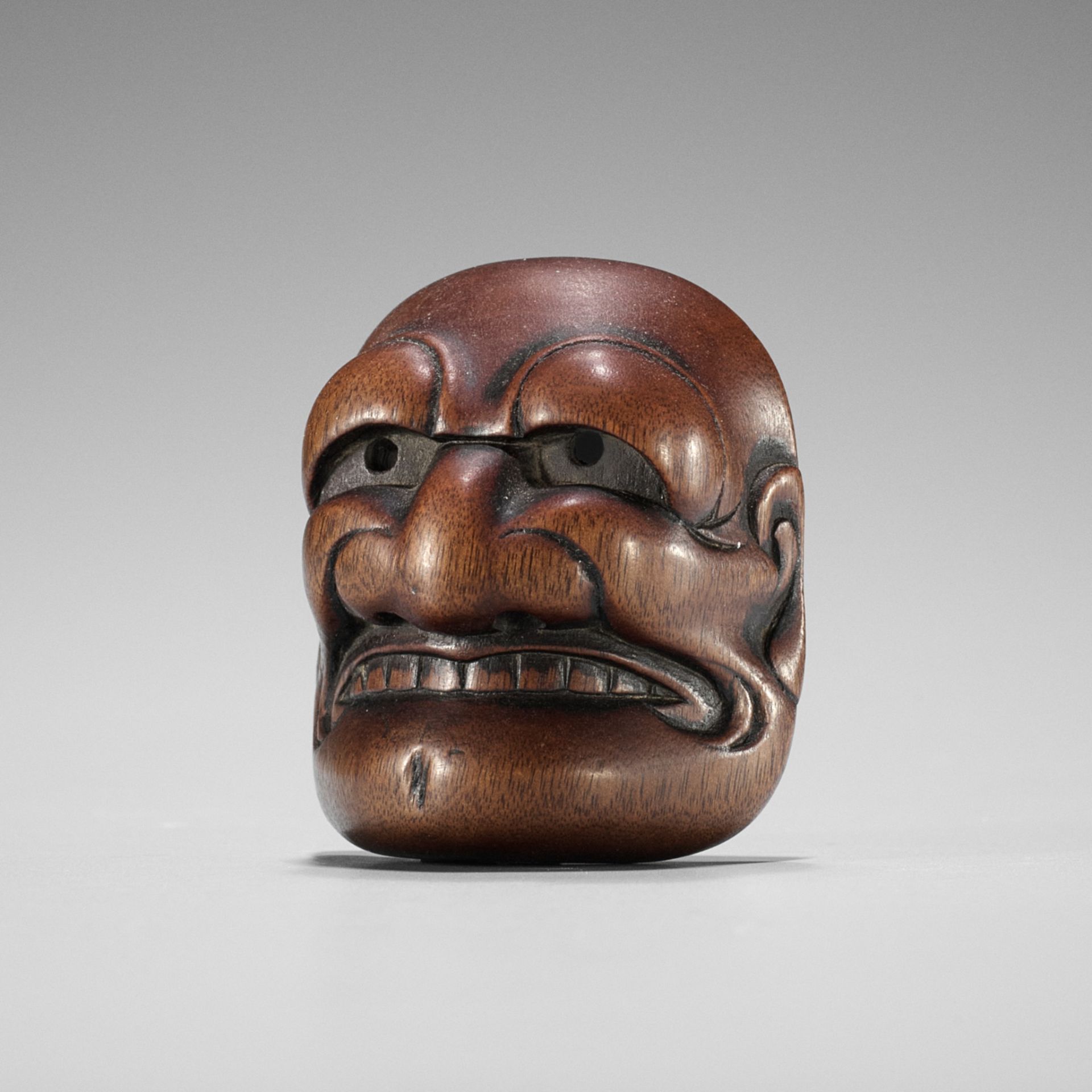 TADATOSHI: A FINE NAGOYA SCHOOL WOOD MASK NETSUKE OF BUAKU