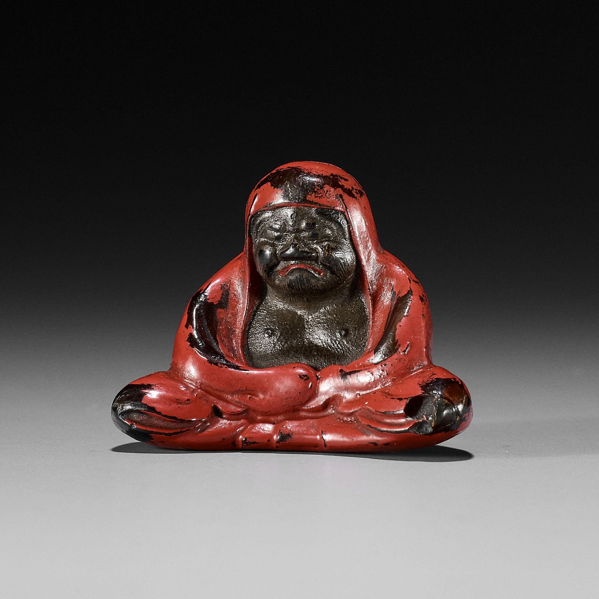 A NEGORO LACQUER NETSUKE OF DARUMA