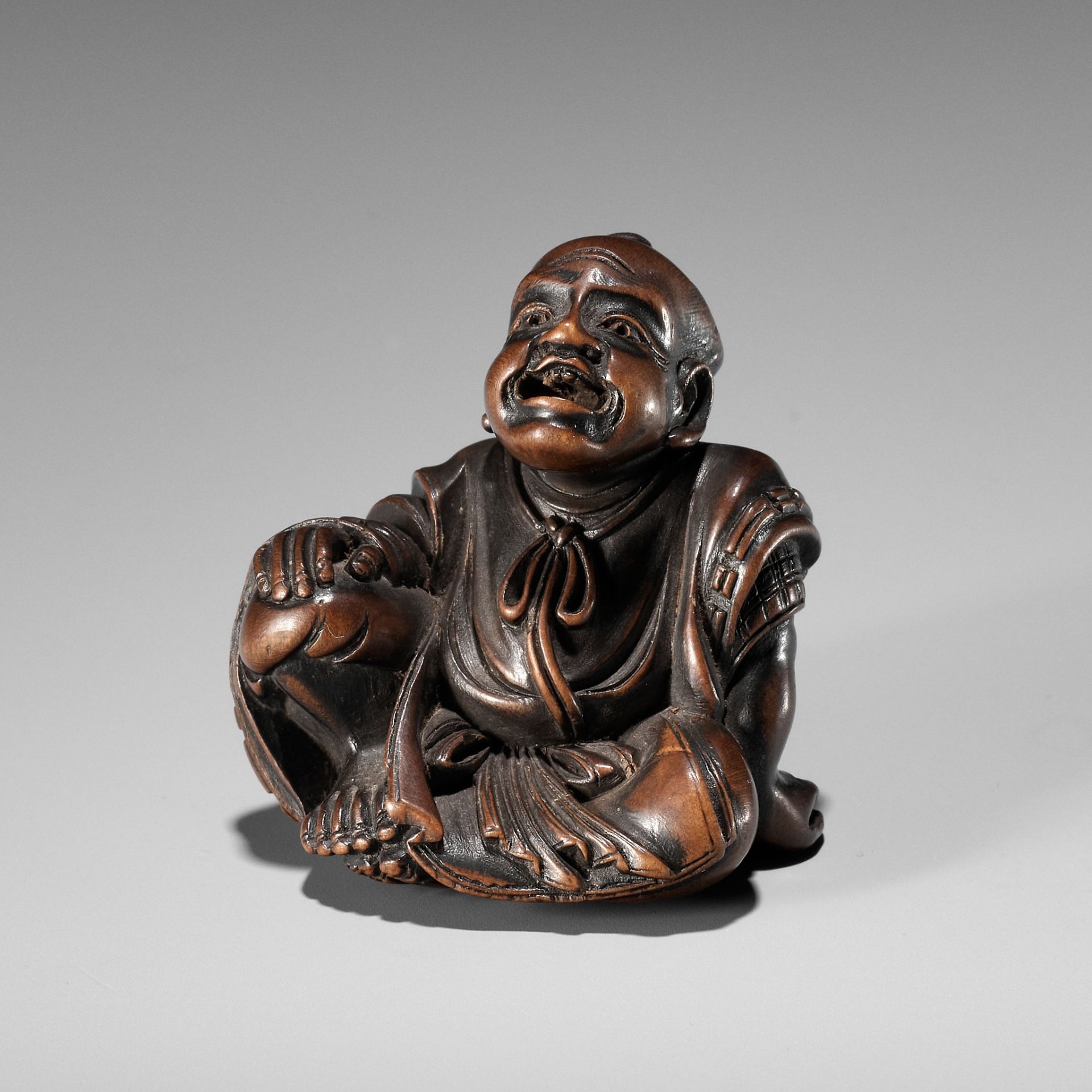 SHUMIN: A FINE WOOD NETSUKE OF A TEMPLE SERVANT