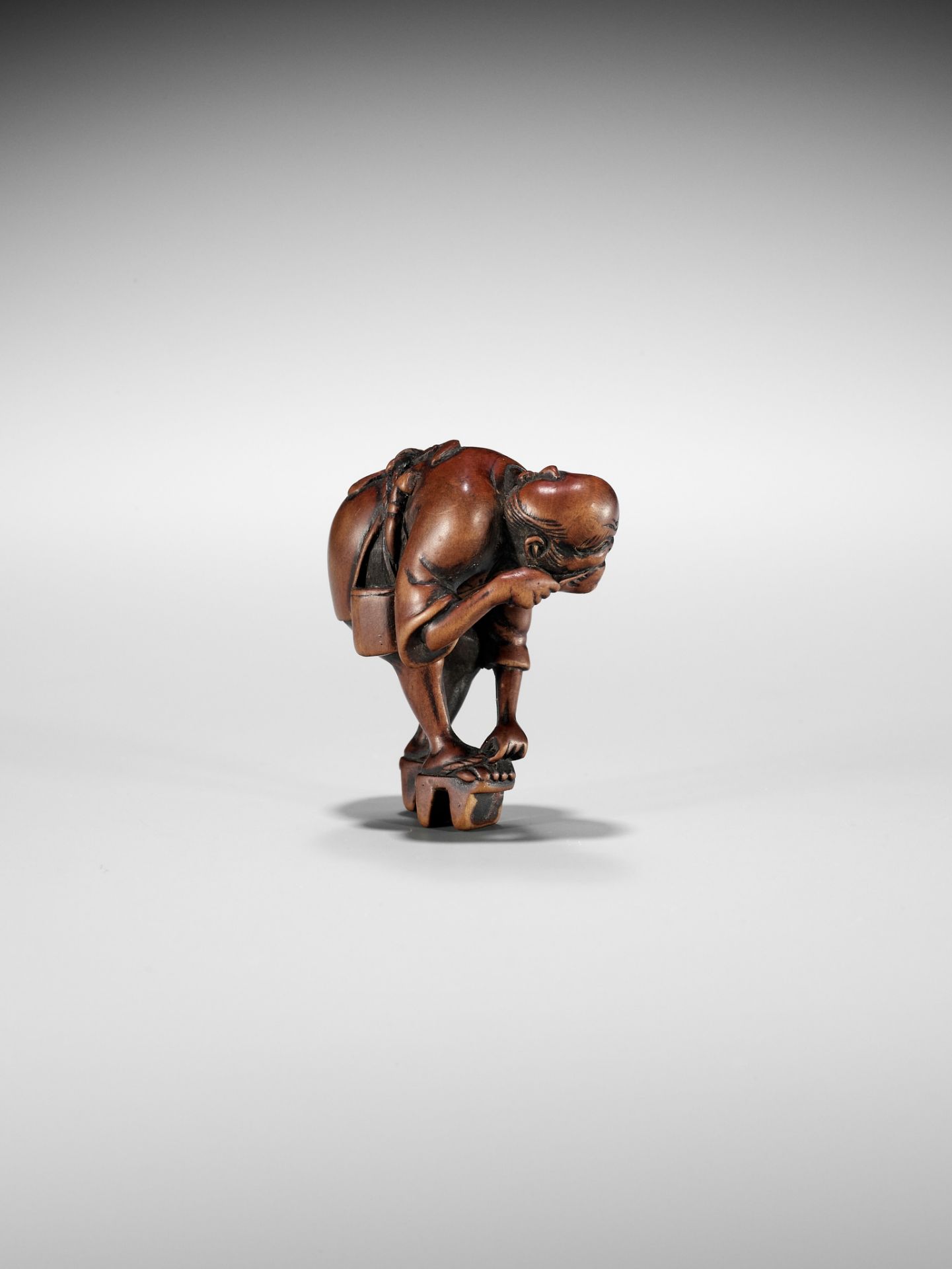 AN EDO SCHOOL WOOD NETSUKE OF A FARMER TYING HIS GETA AND CLEANING HIS TEETH - Image 9 of 11