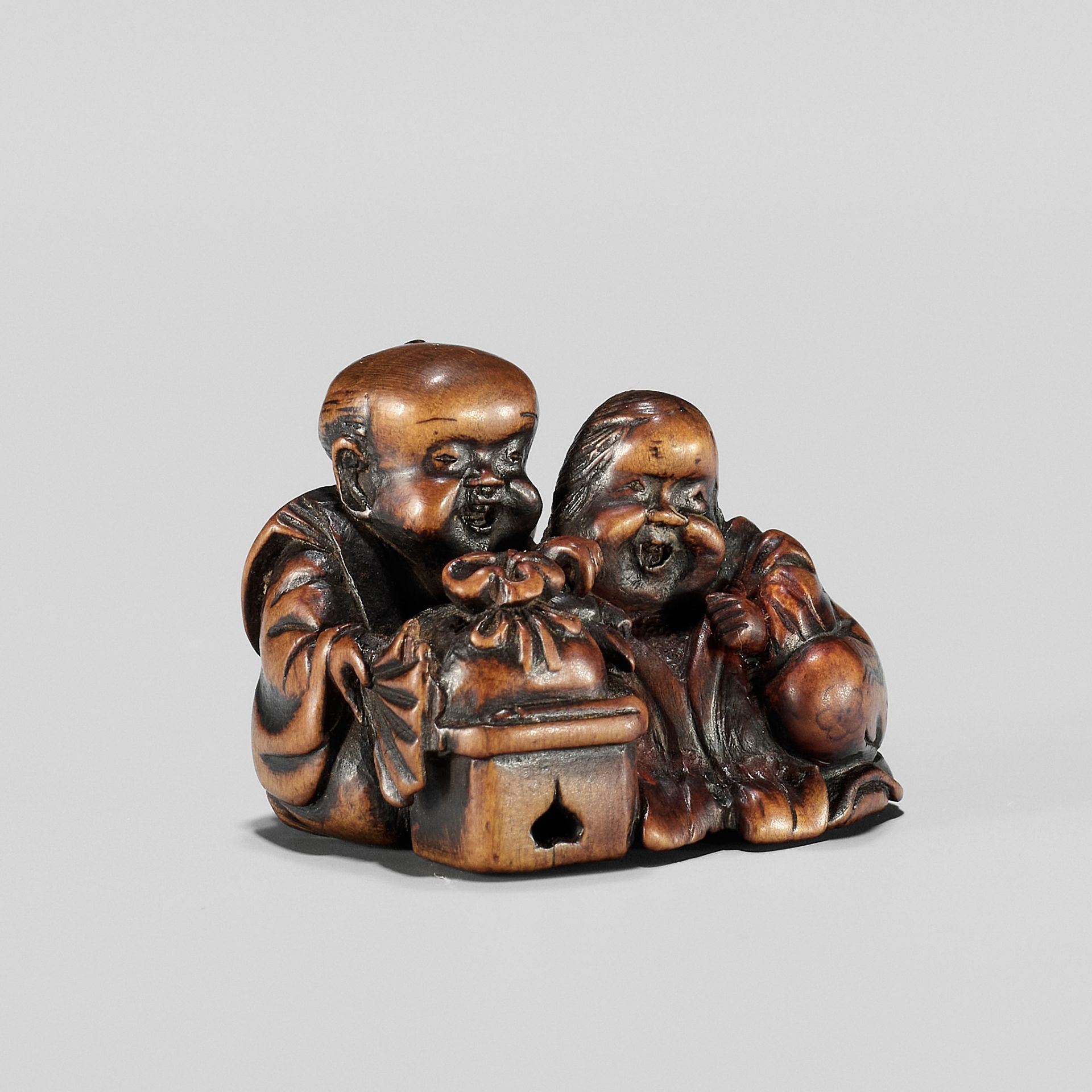 HIDESADA: A FINE WOOD NETSUKE OF OKAME AND FUKUSUKE