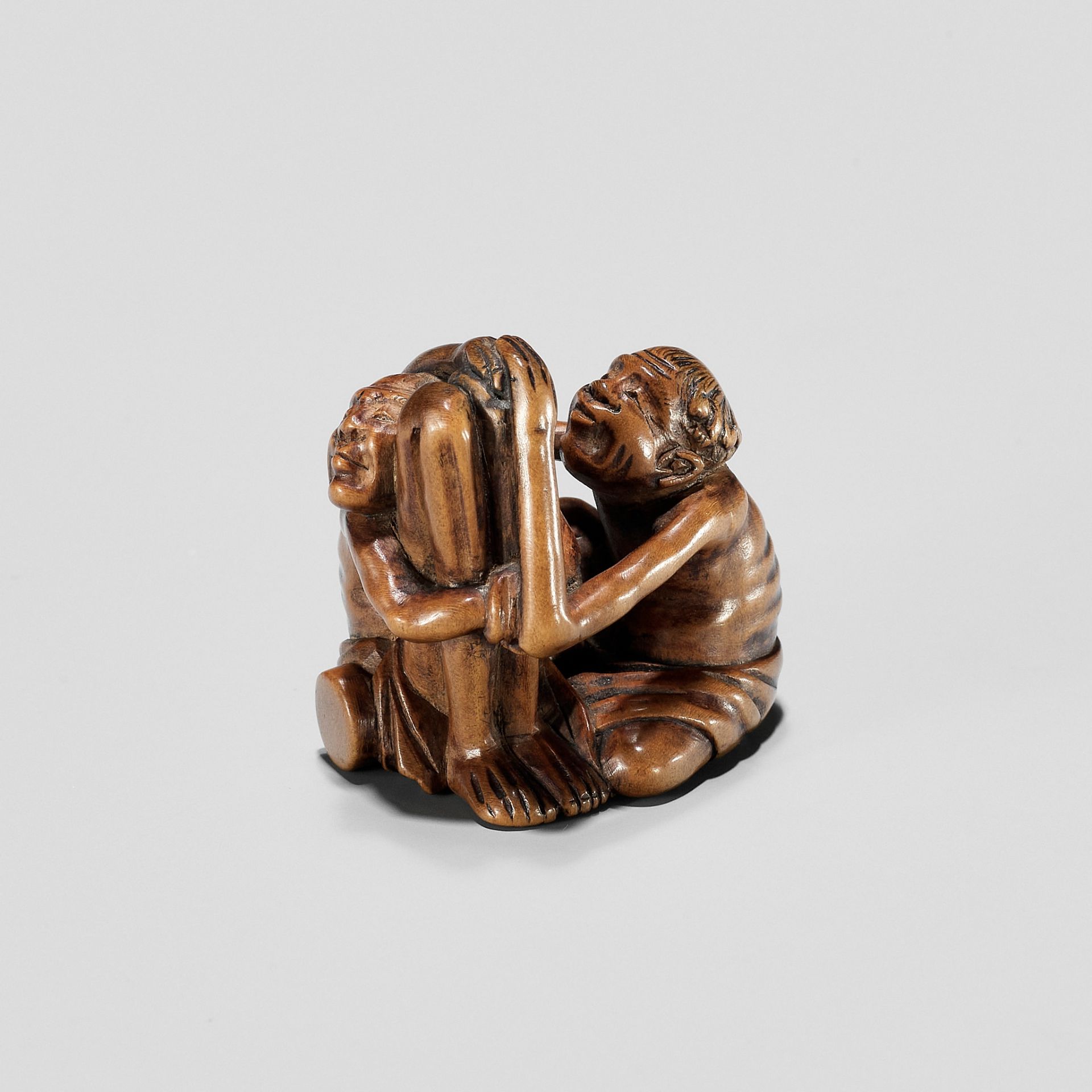 A TOMOCHIKA SCHOOL WOOD NETSUKE OF ASHINAGA AND TENAGA