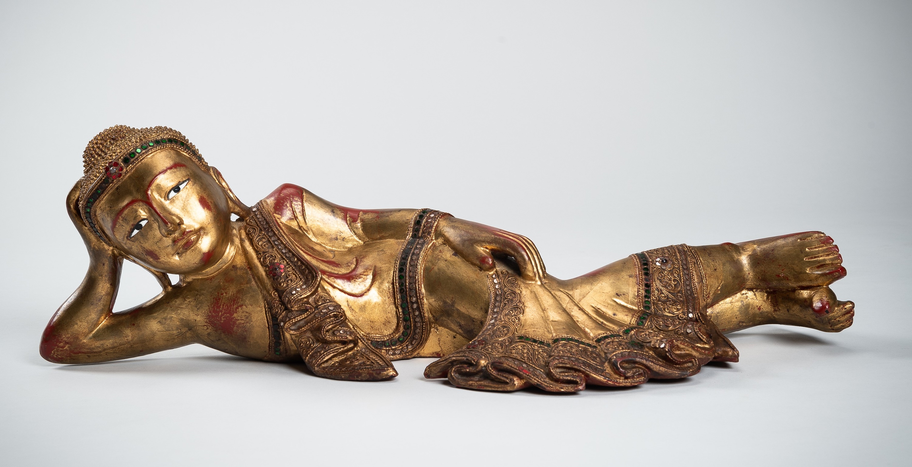 A BURMESE GILT-LACQUERED WOOD FIGURE OF THE RECLINING BUDDHA