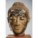A VERY LARGE GILT LACQUERED STUCCO HEAD OF BUDDHA, AYUTTHAYA PERIOD