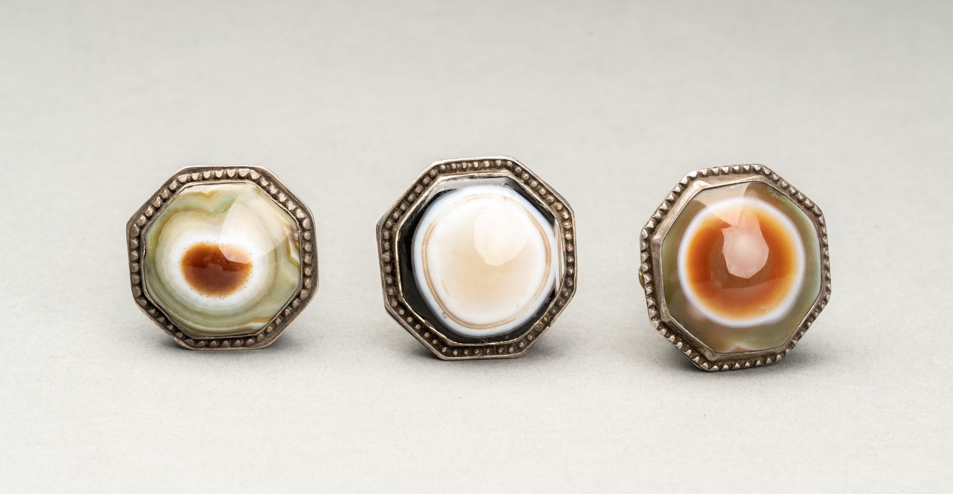 A GROUP OF THREE HIMALAYAN BUDDHA EYE AGATE INSET SILVER RINGS