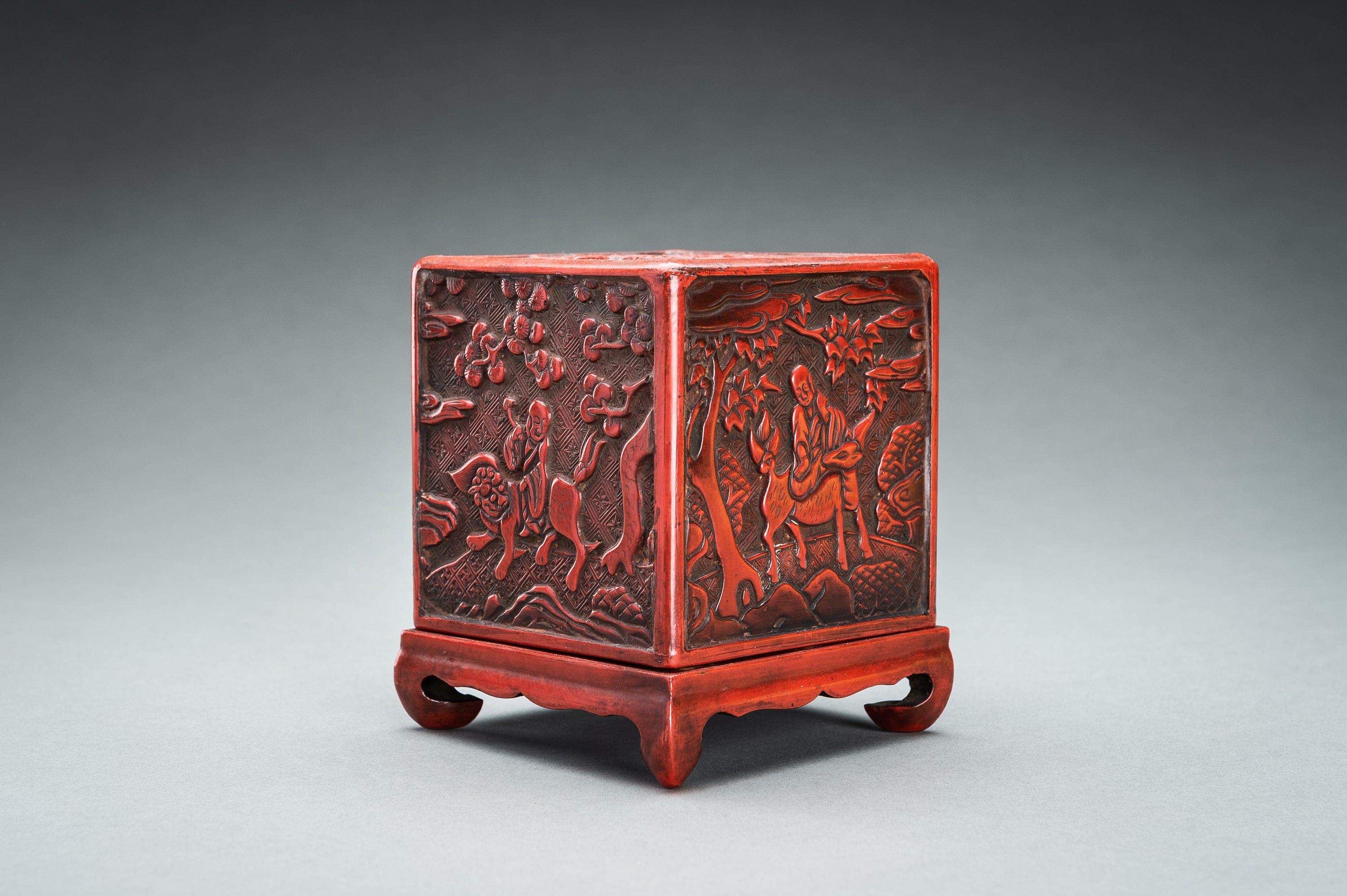 A CINNABAR LACQUER 'IMMORTALS AND BUDAI' BOX AND COVER, QING