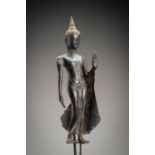 A RATTANAKOSIN SILVER REPOUSSE FIGURE OF A 'WALKING BUDDHA'