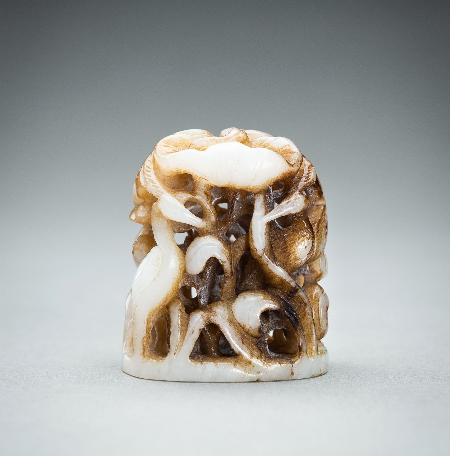 A WHITE AND RUSSET JADE 'CRANE AND LOTUS' FINIAL, QING