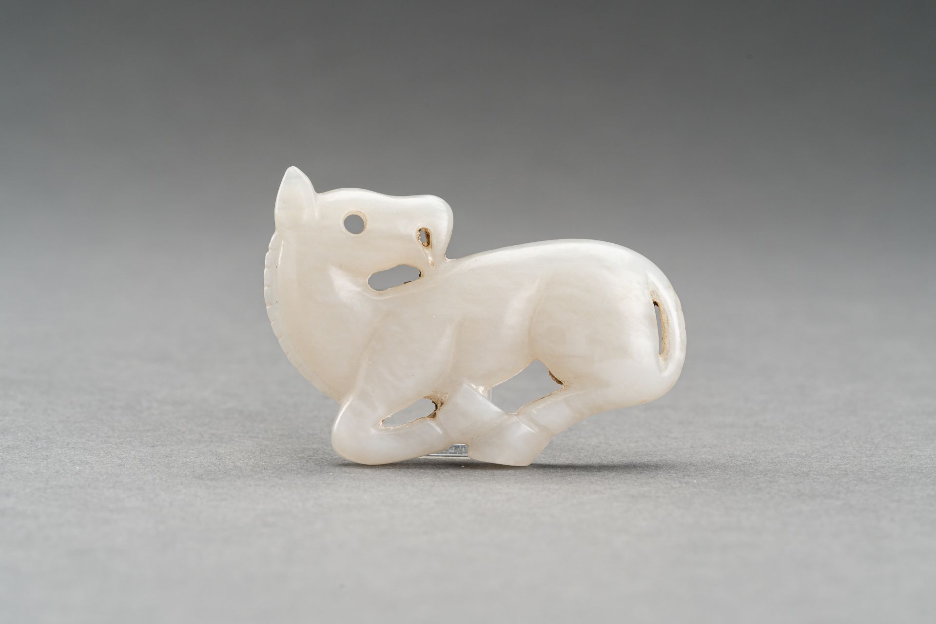 A GRAY JADE PENDANT OF A RECUMBENT HORSE, c. 1920s